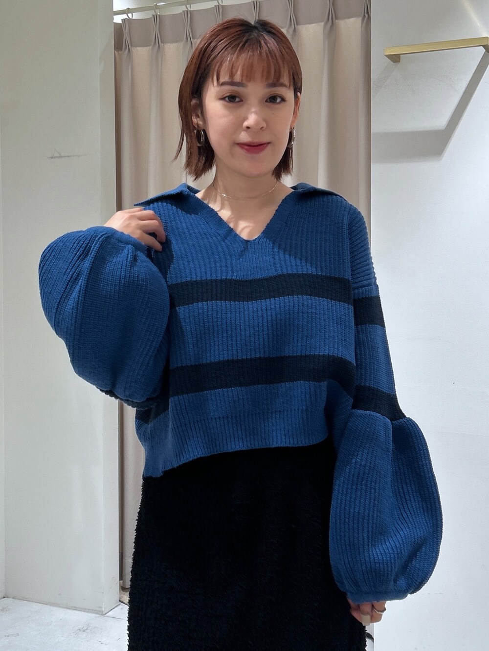 ブルー系のニット/セーター、ブラック系のスカートを着用したレディースの秋コーディネートの3枚目の写真