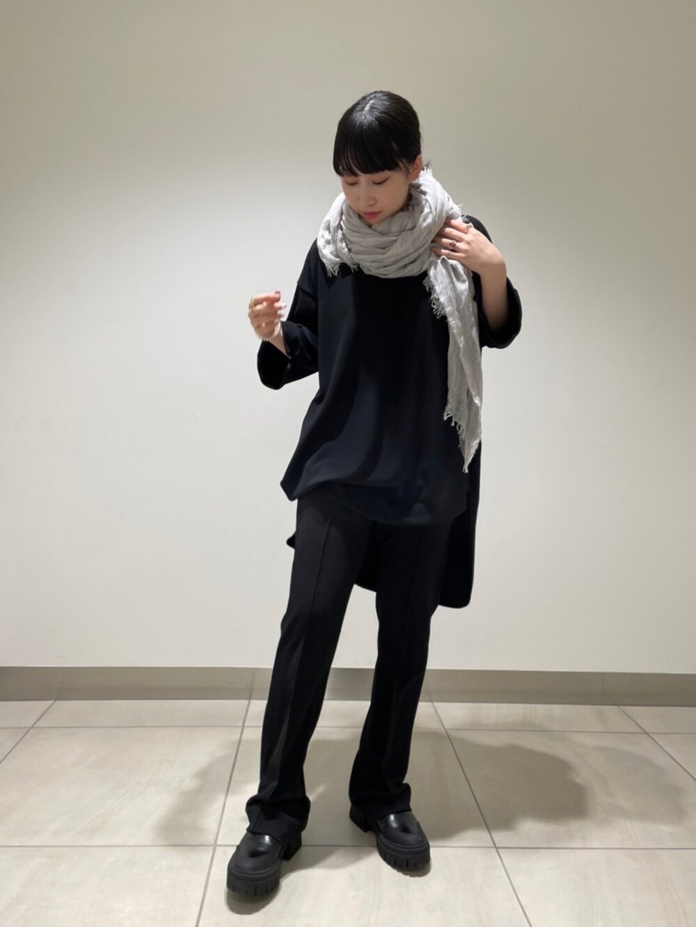 ブラック系のパンツ、ブラック系のTシャツ/カットソー、グレー系のストール/ショールを着用したレディースの冬コーディネートの2枚目の写真