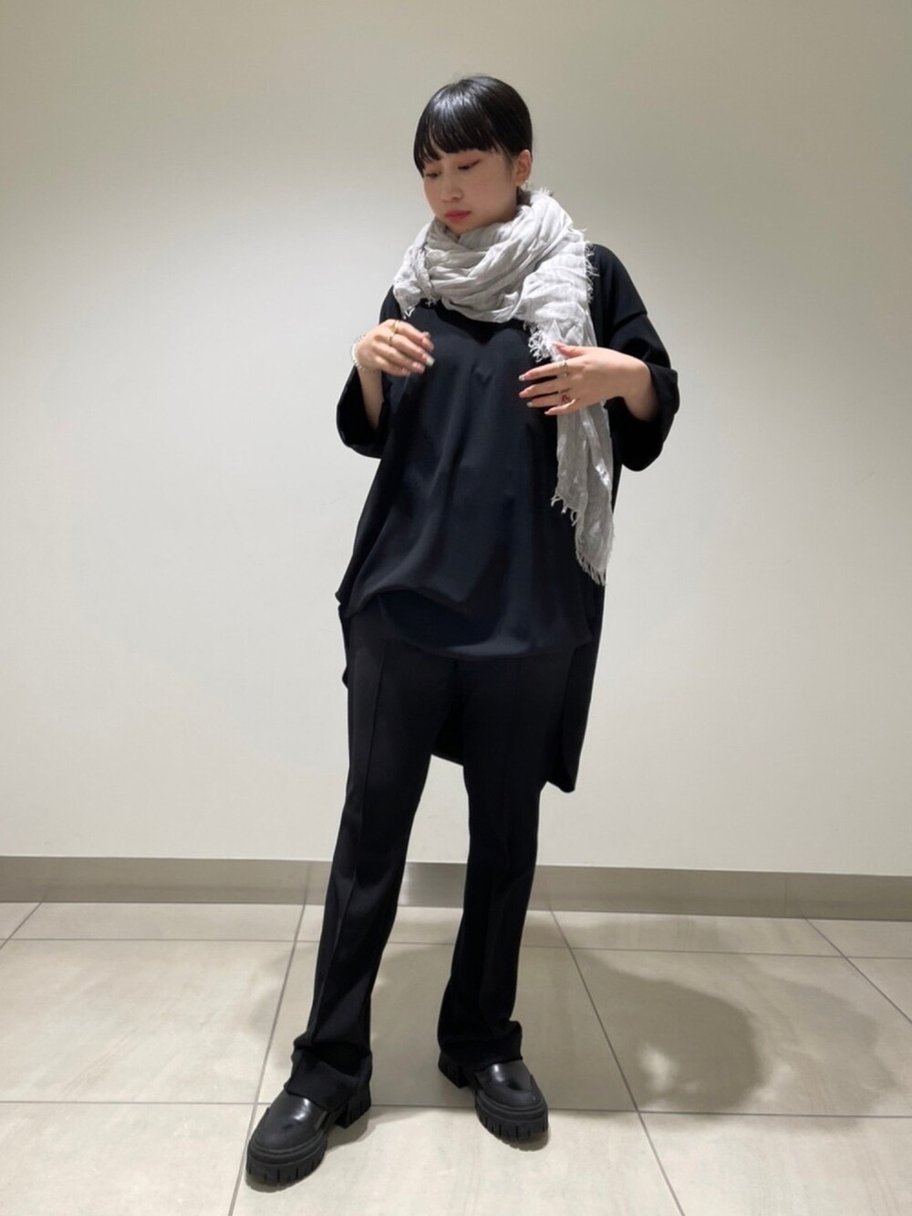 ブラック系のパンツ、ブラック系のTシャツ/カットソー、グレー系のストール/ショールを着用したレディースの冬コーディネートの4枚目の写真