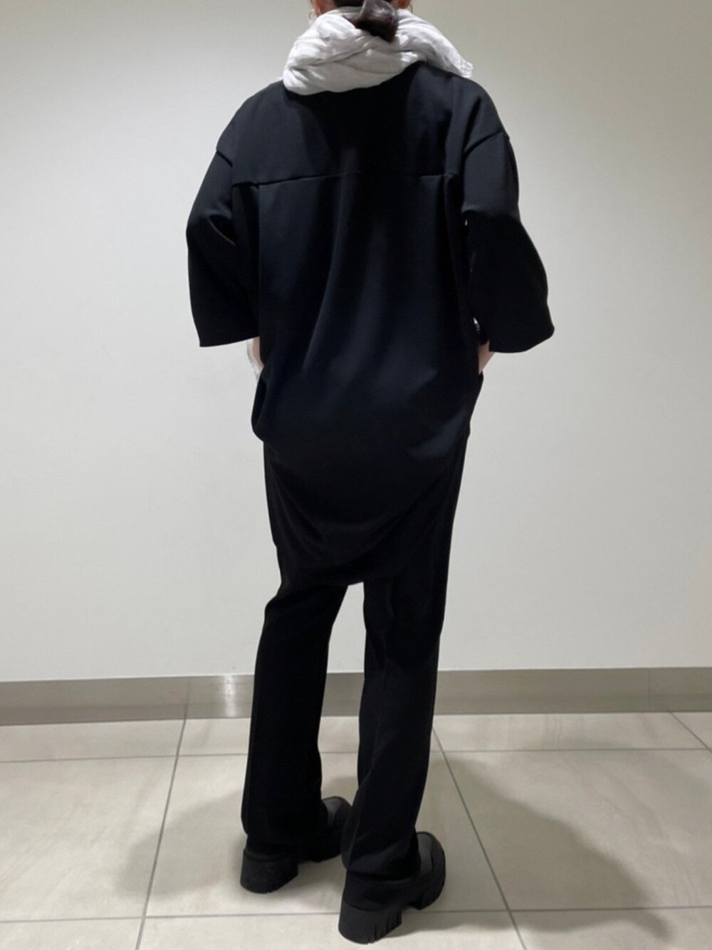 ブラック系のパンツ、ブラック系のTシャツ/カットソー、グレー系のストール/ショールを着用したレディースの冬コーディネートの5枚目の写真