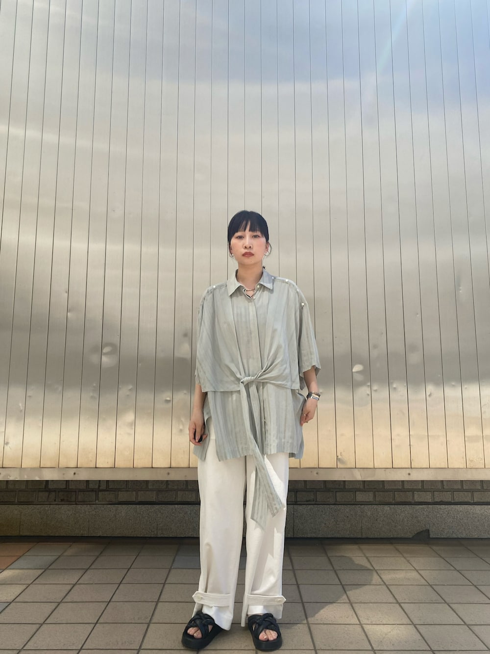 グレー系のシャツ/ブラウス、ホワイト系のパンツ、シルバー系のネックレスを着用したレディースの春コーディネートの3枚目の写真