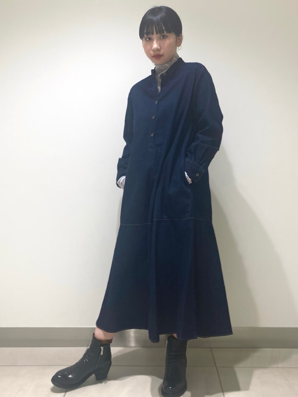 ブラック系のブーツ、ピンク系のTシャツ/カットソー、ブルー系のワンピースを着用したレディースの冬コーディネートの2枚目の写真