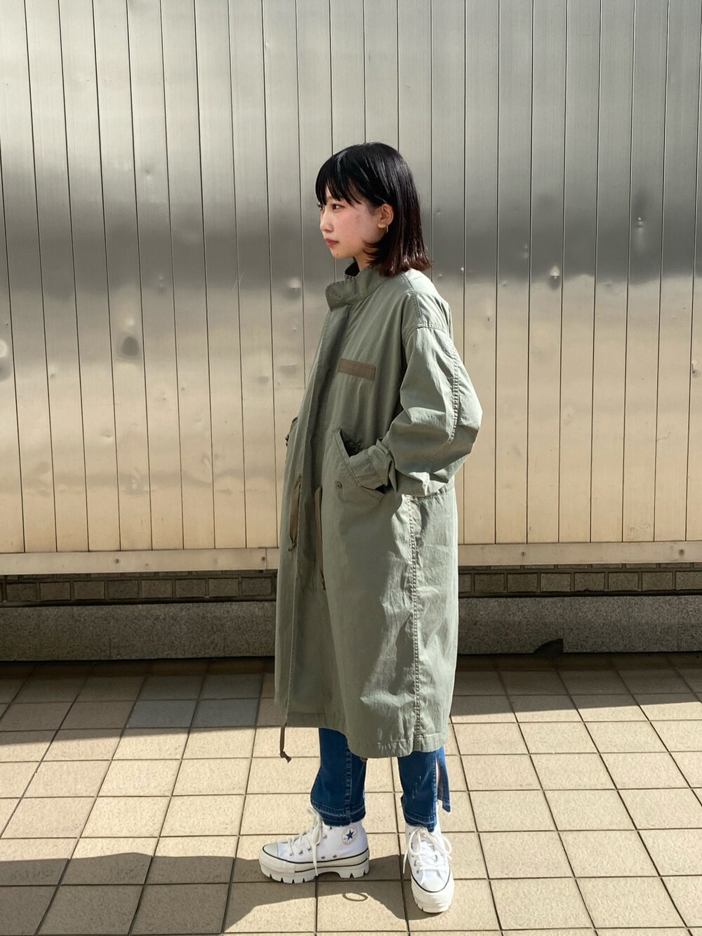 ブルー系のデニムパンツ、ホワイト系のTシャツ/カットソー、シルバー系のネックレスを着用したレディースの春コーディネートの2枚目の写真