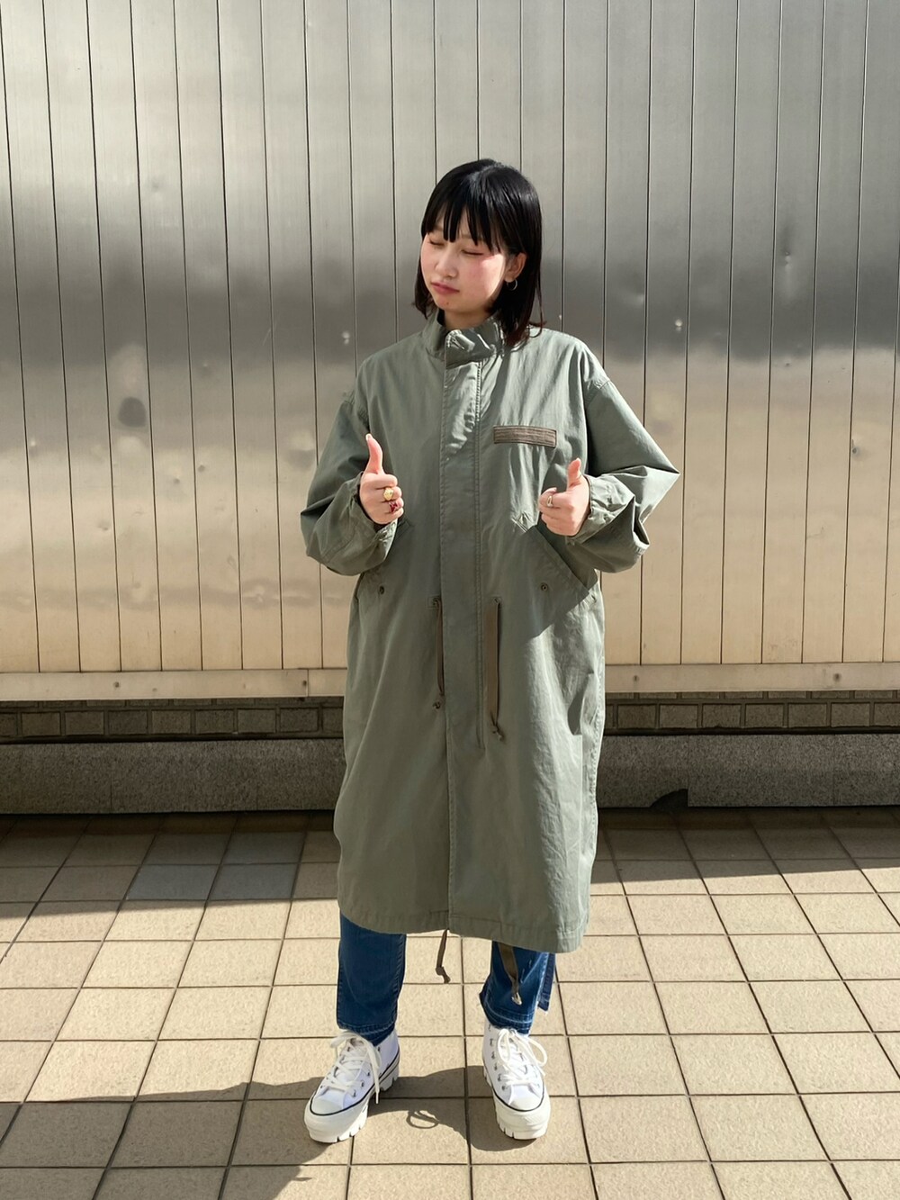 ブルー系のデニムパンツ、ホワイト系のTシャツ/カットソー、シルバー系のネックレスを着用したレディースの春コーディネートの4枚目の写真