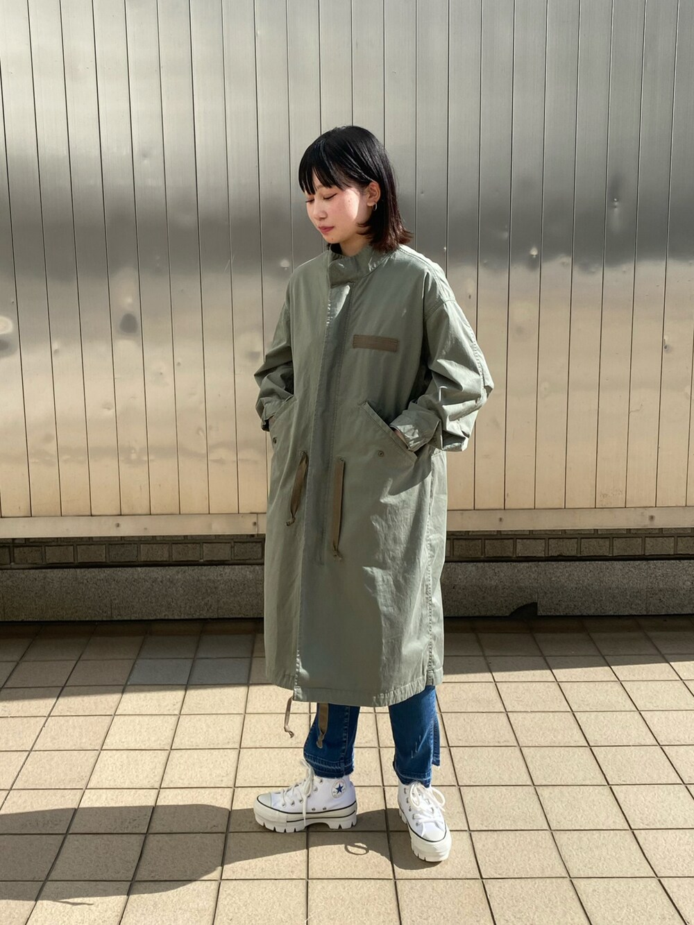 ブルー系のデニムパンツ、ホワイト系のTシャツ/カットソー、シルバー系のネックレスを着用したレディースの春コーディネートの3枚目の写真