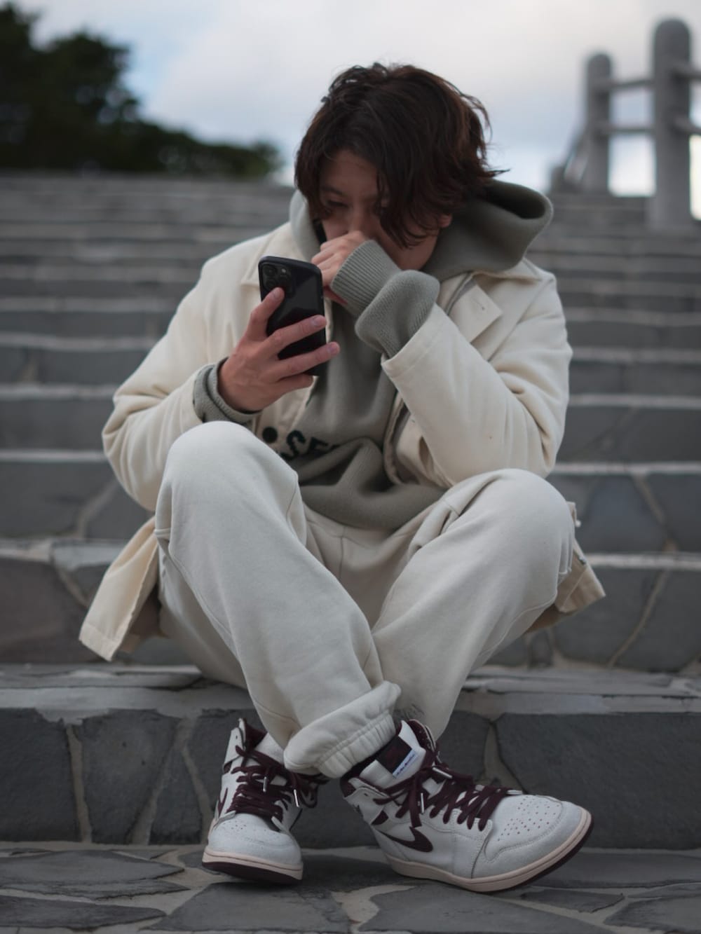 ベージュ系のスウェットパンツ、グリーン系のパーカー、ホワイト系のジャケット/アウターを着用したメンズの冬コーディネートの2枚目の写真