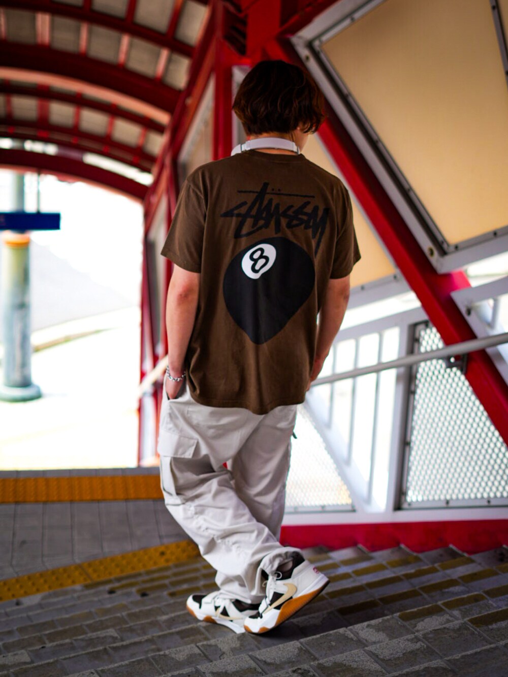 ホワイト系のカーゴパンツ、ブラウン系のTシャツ/カットソー、ホワイト系のスニーカーを着用したメンズの春コーディネートの2枚目の写真