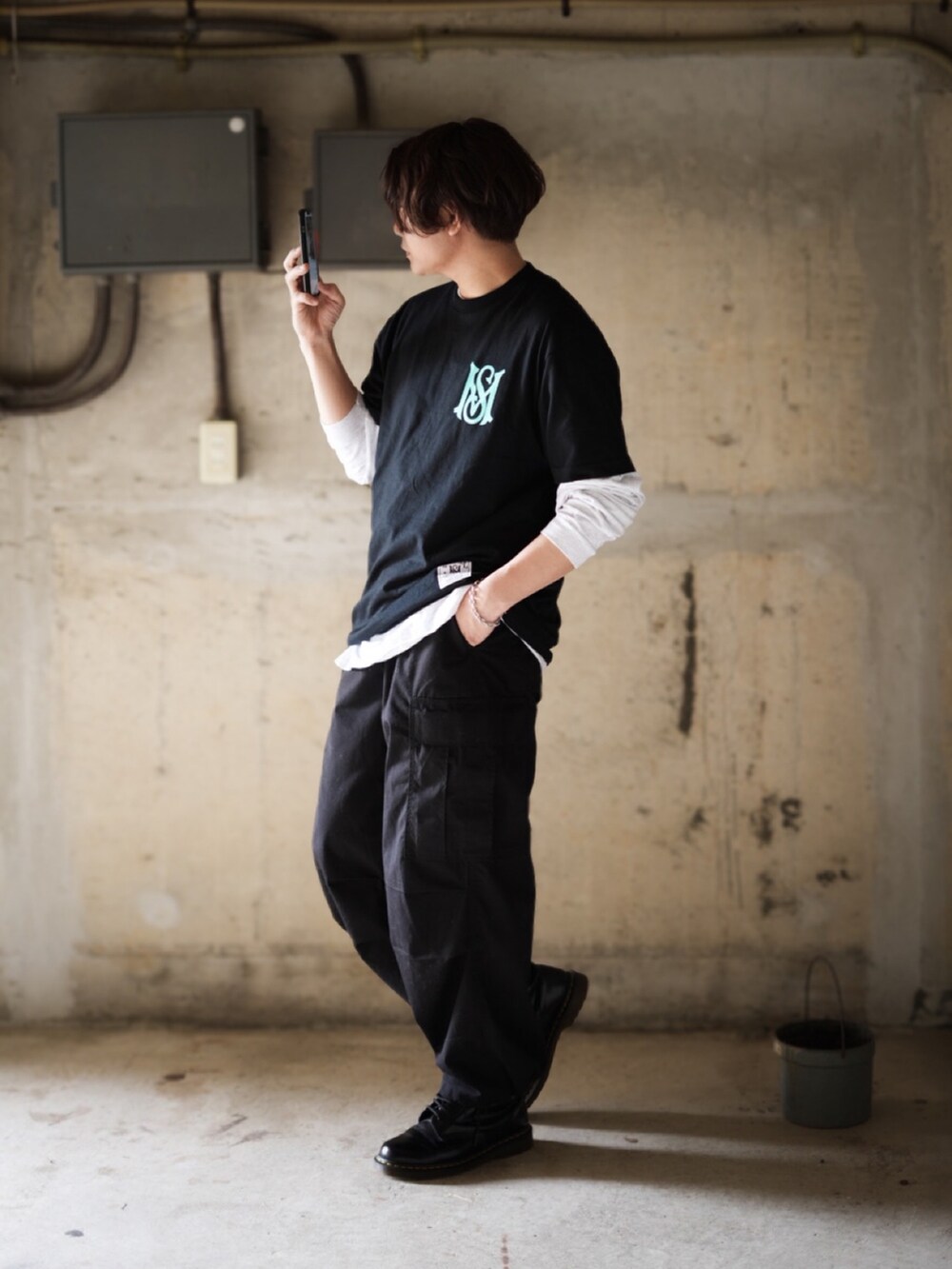 ブラック系のカーゴパンツ、ブラック系のブーツ、ブラック系のTシャツ/カットソーを着用したメンズの春コーディネートの2枚目の写真