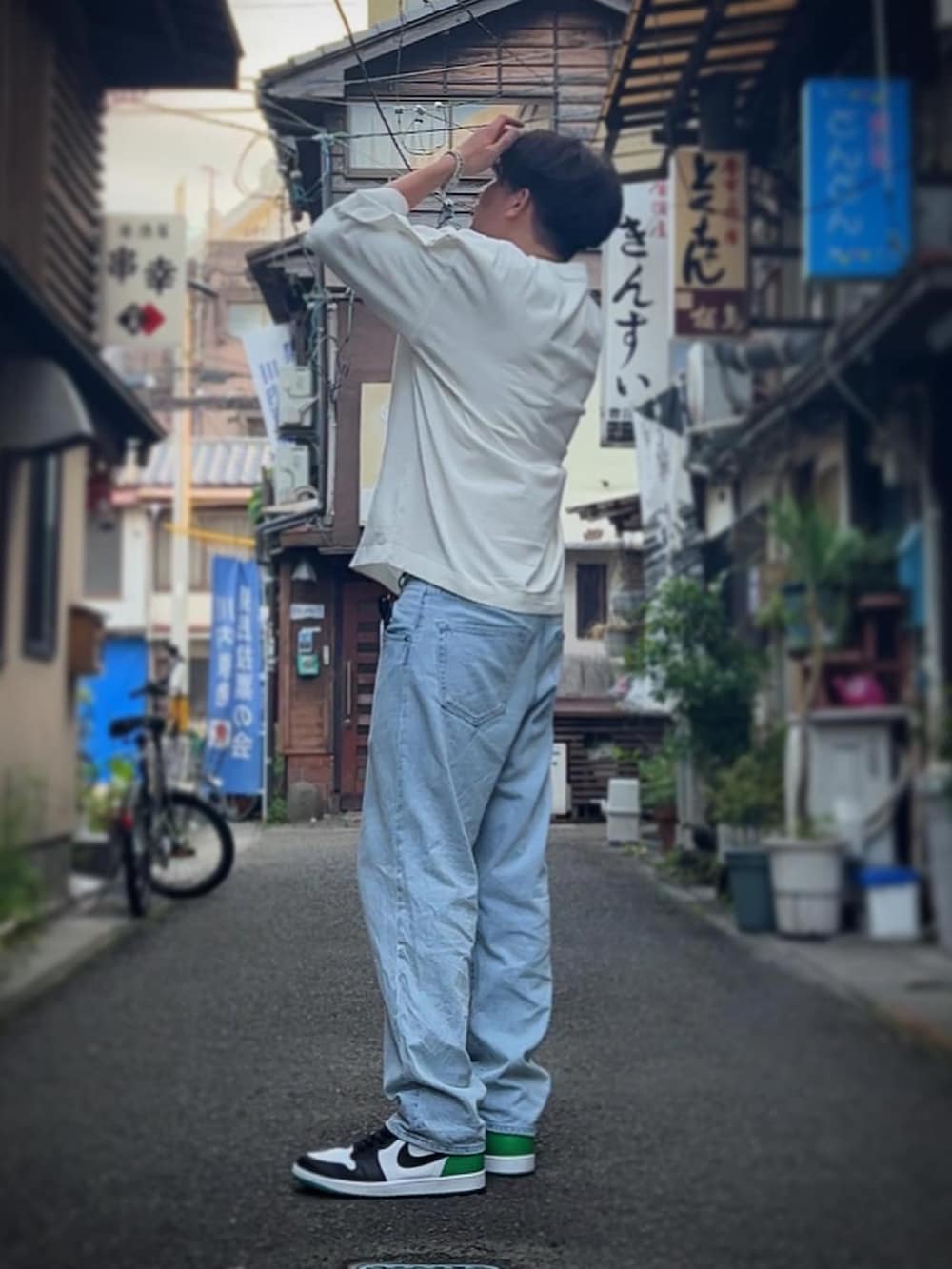 ブルー系のデニムパンツ、グリーン系のスニーカー、ホワイト系のTシャツ/カットソーを着用したメンズの夏コーディネートの2枚目の写真