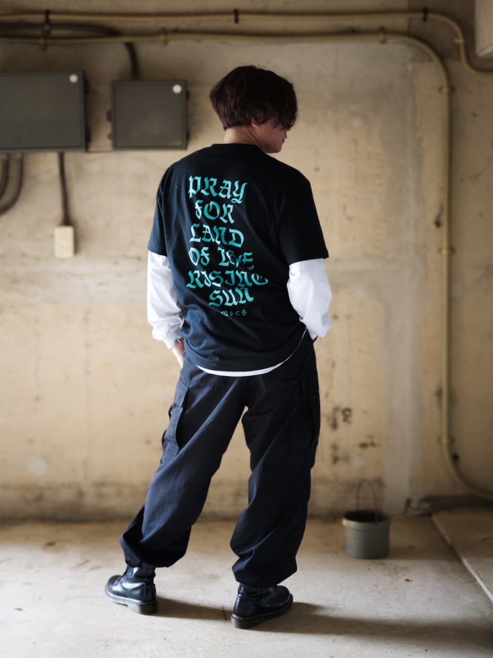 ブラック系のカーゴパンツ、ブラック系のブーツ、ブラック系のTシャツ/カットソーを着用したメンズの春コーディネートの3枚目の写真