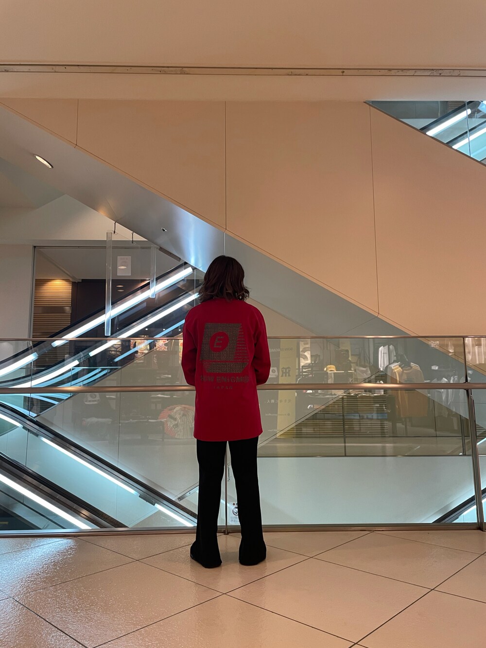 レッド系のTシャツ/カットソーを着用したレディースの秋コーディネートの2枚目の写真