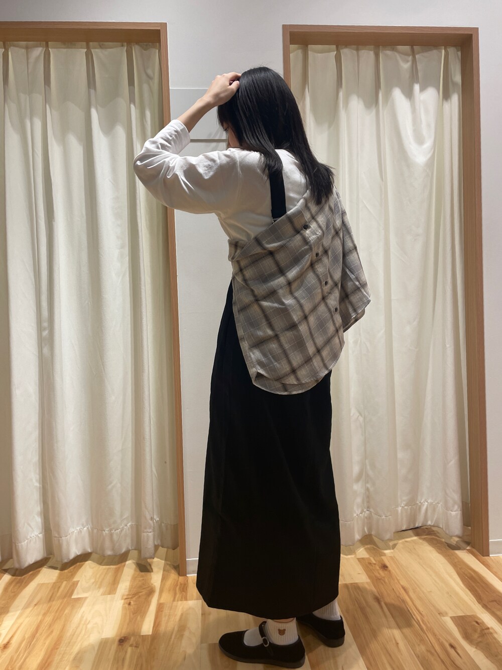 ホワイト系のTシャツ/カットソー、ブラック系のジャンパースカート、ベージュ系のシャツ/ブラウスを着用したレディースの秋コーディネートの2枚目の写真