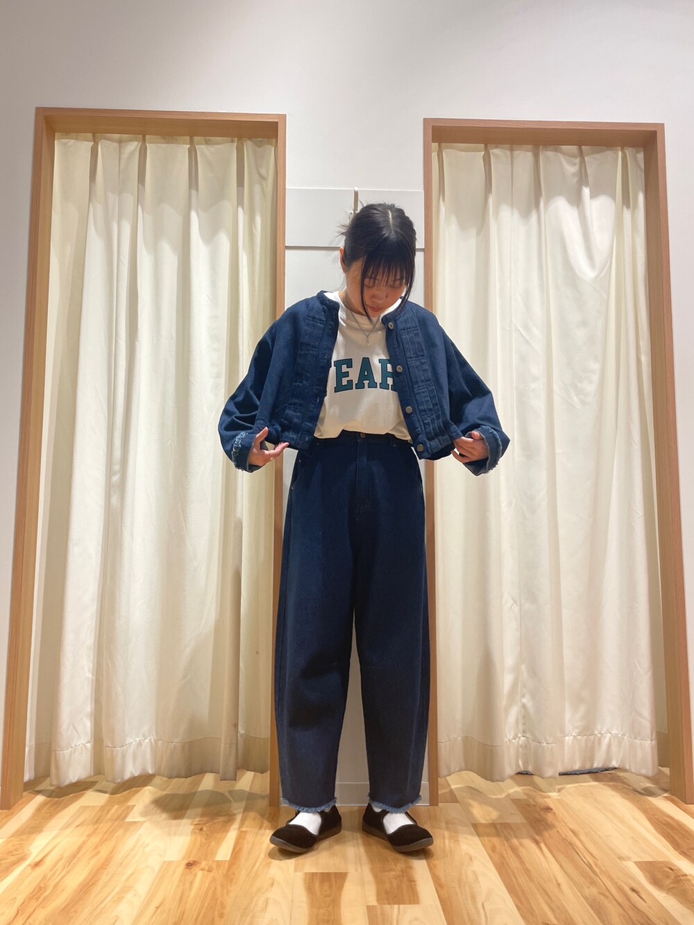 ブルー系のデニムジャケット、ブルー系のデニムパンツ、ホワイト系のTシャツ/カットソーを着用したレディースの秋コーディネートの2枚目の写真