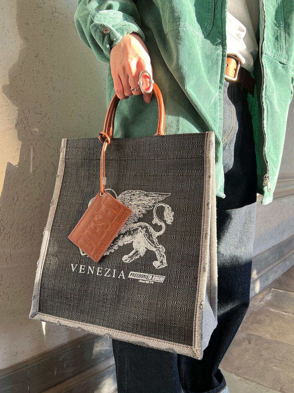 ホワイト系のTシャツ/カットソー、グリーン系のシャツ/ブラウス、ブルー系のデニムパンツを着用したメンズの春コーディネートの2枚目の写真