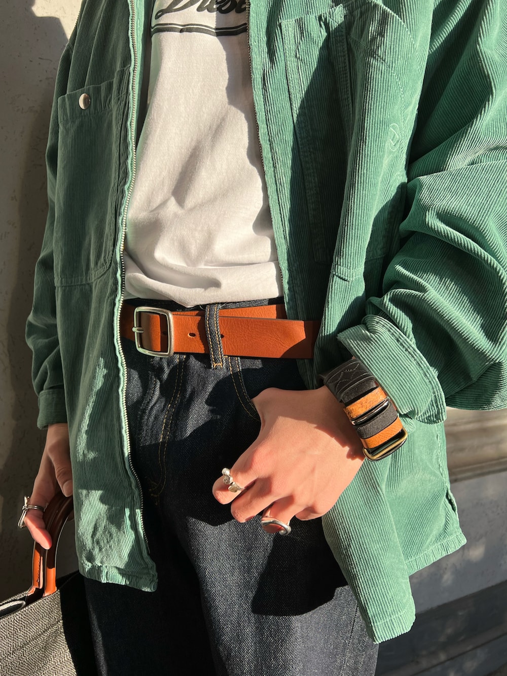 ホワイト系のTシャツ/カットソー、グリーン系のシャツ/ブラウス、ブルー系のデニムパンツを着用したメンズの春コーディネートの4枚目の写真