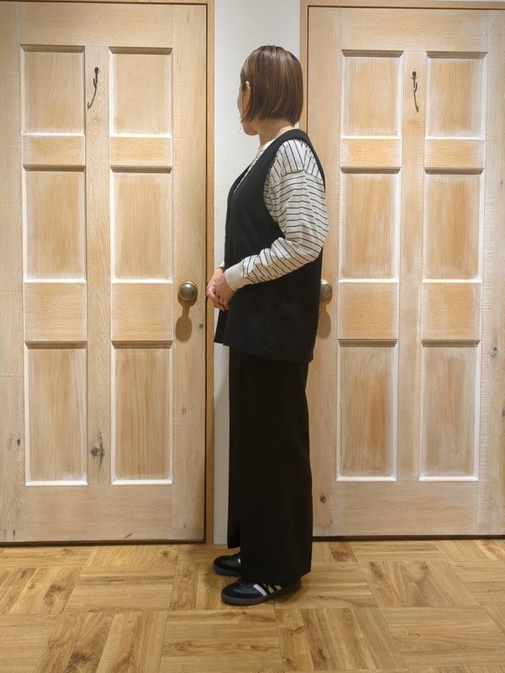 ブラック系のスラックス、ブラック系のTシャツ/カットソーを着用したレディースの冬コーディネートの2枚目の写真