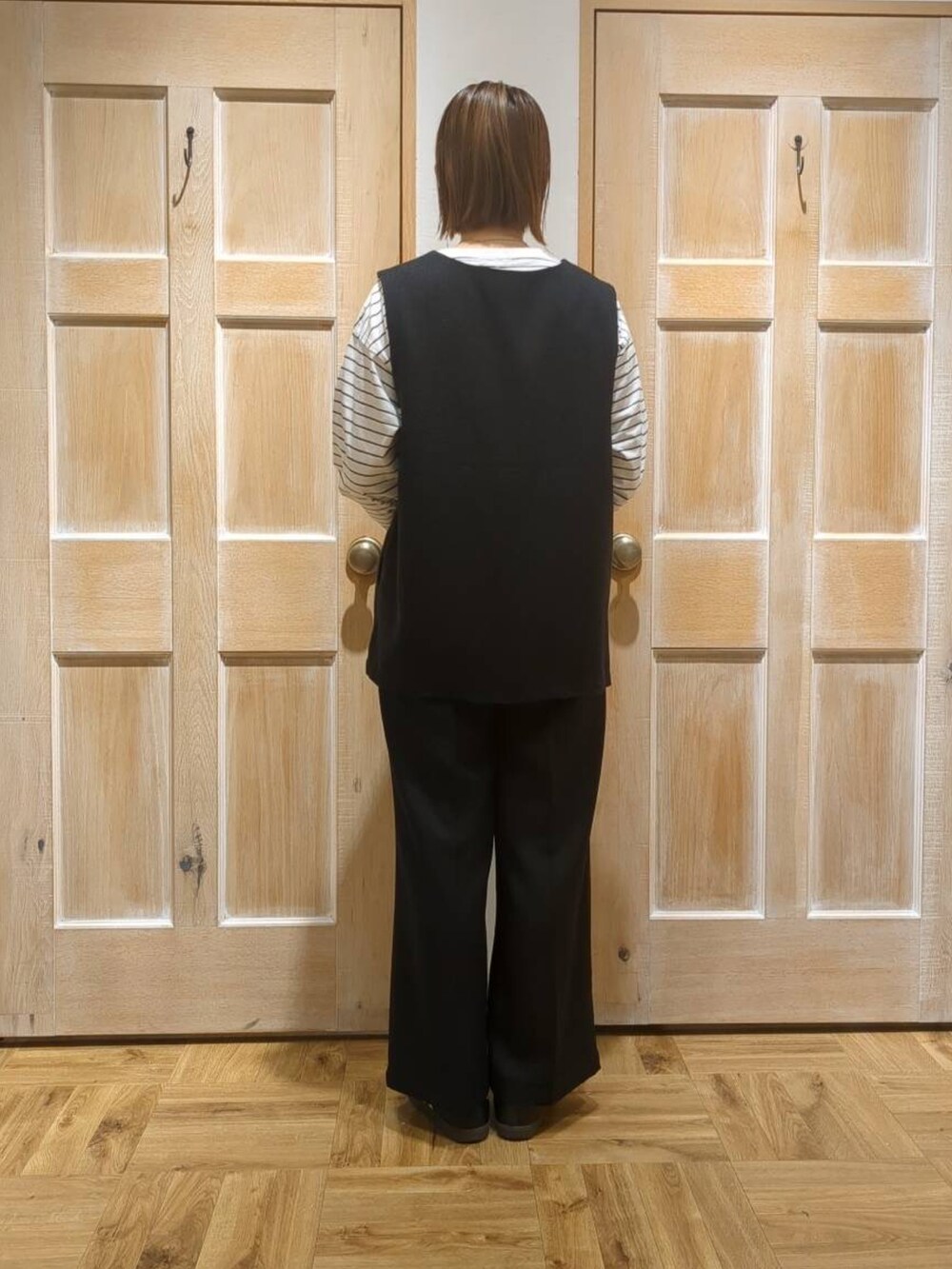 ブラック系のスラックス、ブラック系のTシャツ/カットソーを着用したレディースの冬コーディネートの3枚目の写真