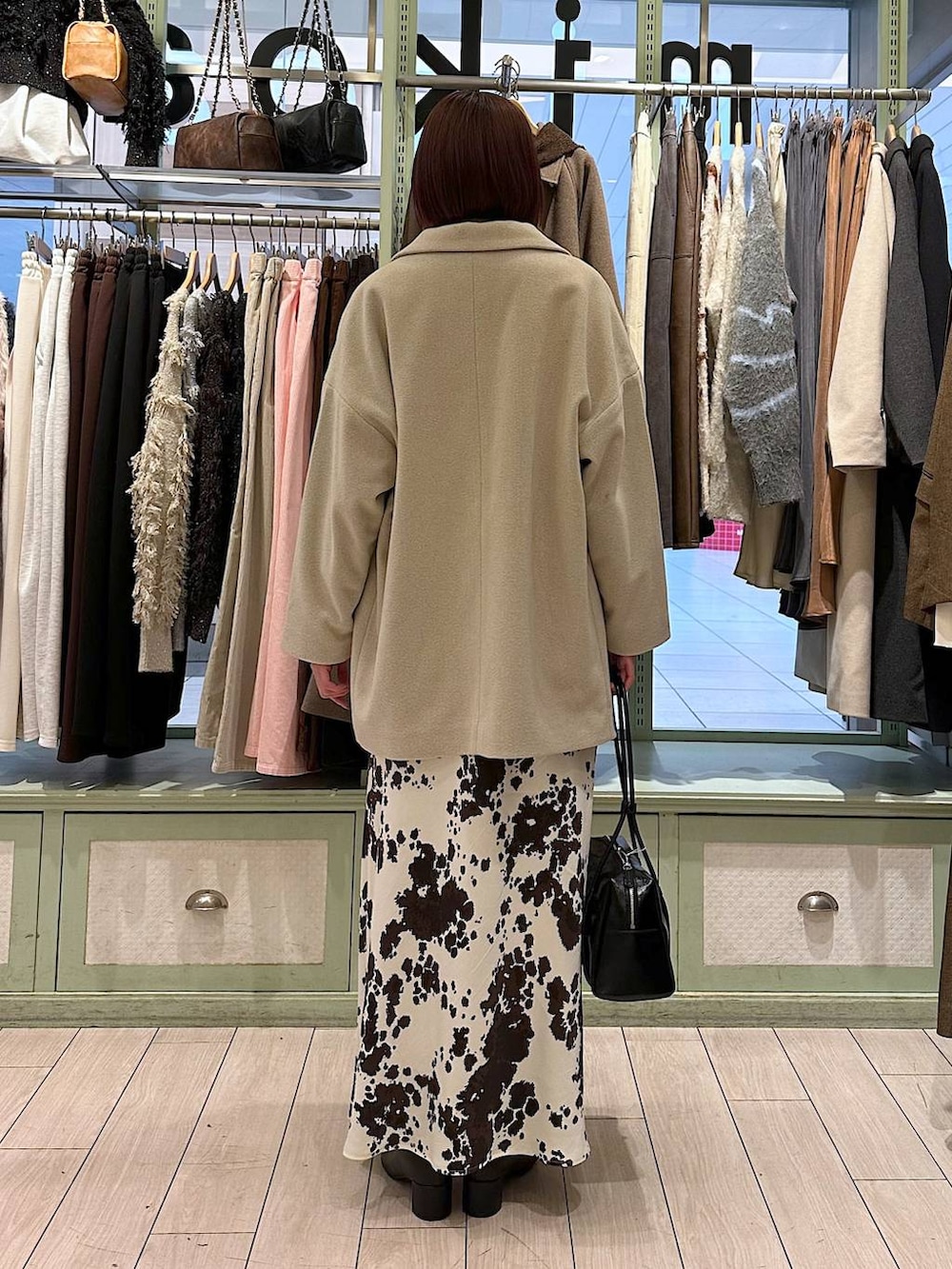 その他のスカート、ブラウン系のニット/セーター、ホワイト系のその他アウターを着用したレディースの秋コーディネートの3枚目の写真