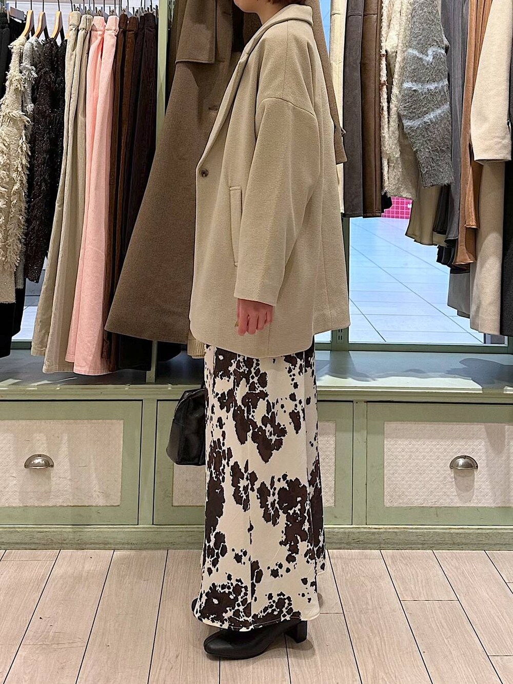 その他のスカート、ブラウン系のニット/セーター、ホワイト系のその他アウターを着用したレディースの秋コーディネートの2枚目の写真