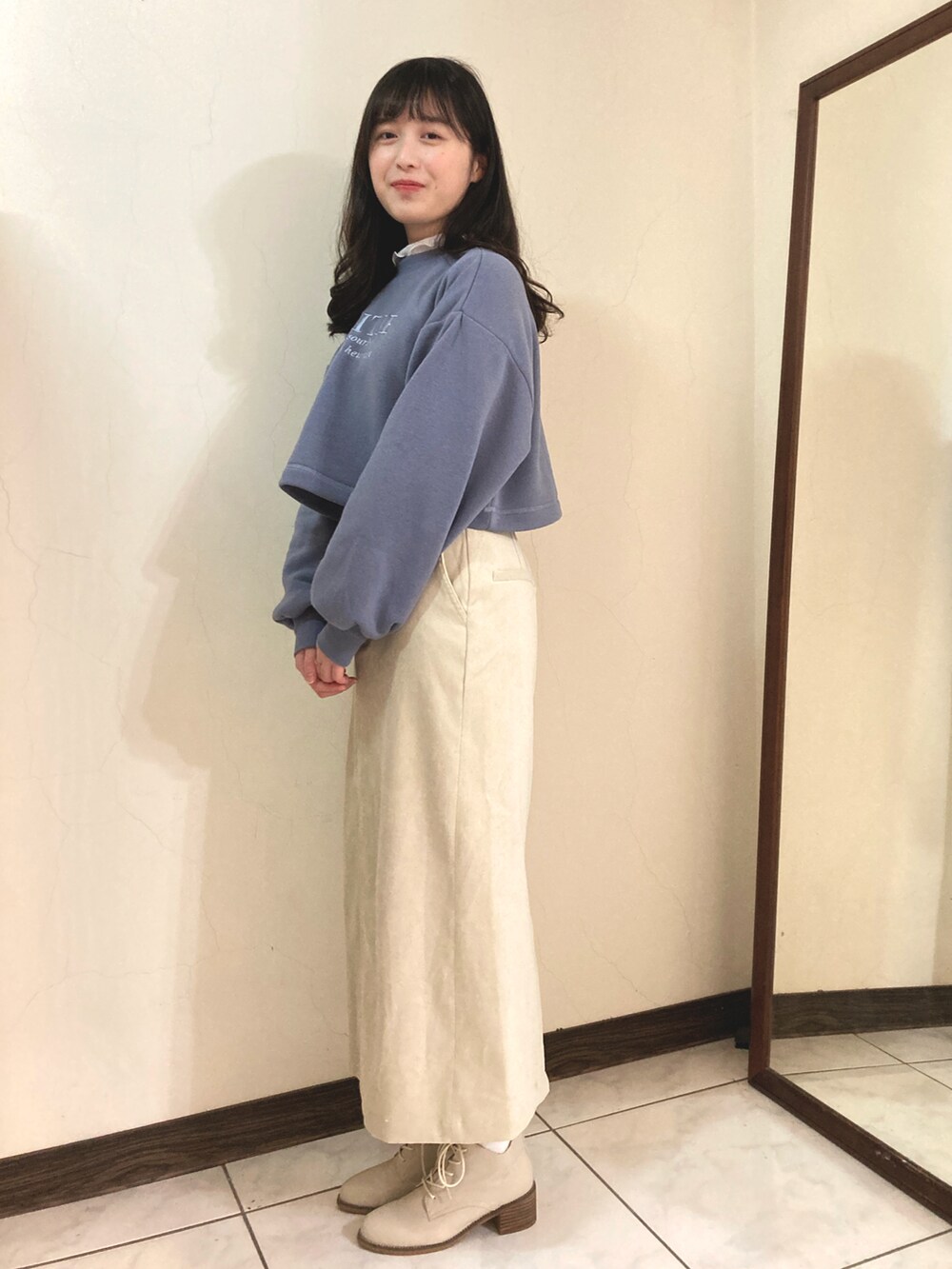 ブルー系のスウェット、ホワイト系のスカートを着用したレディースの冬コーディネートの2枚目の写真