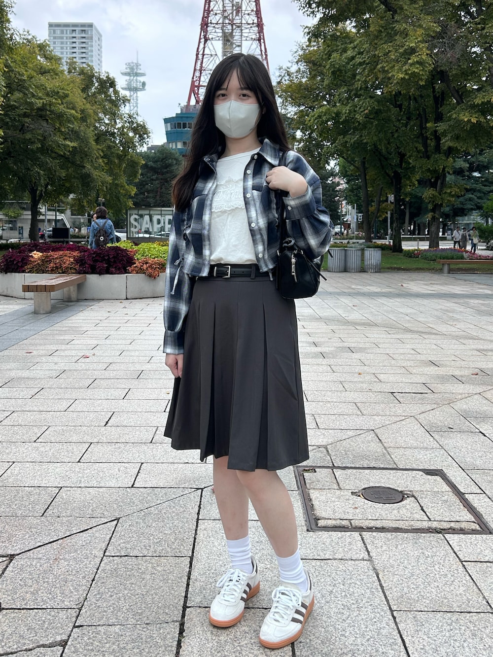 ブルー系のシャツ/ブラウス、ベージュ系のスニーカー、グレー系のスカートを着用したレディースの秋コーディネートの2枚目の写真