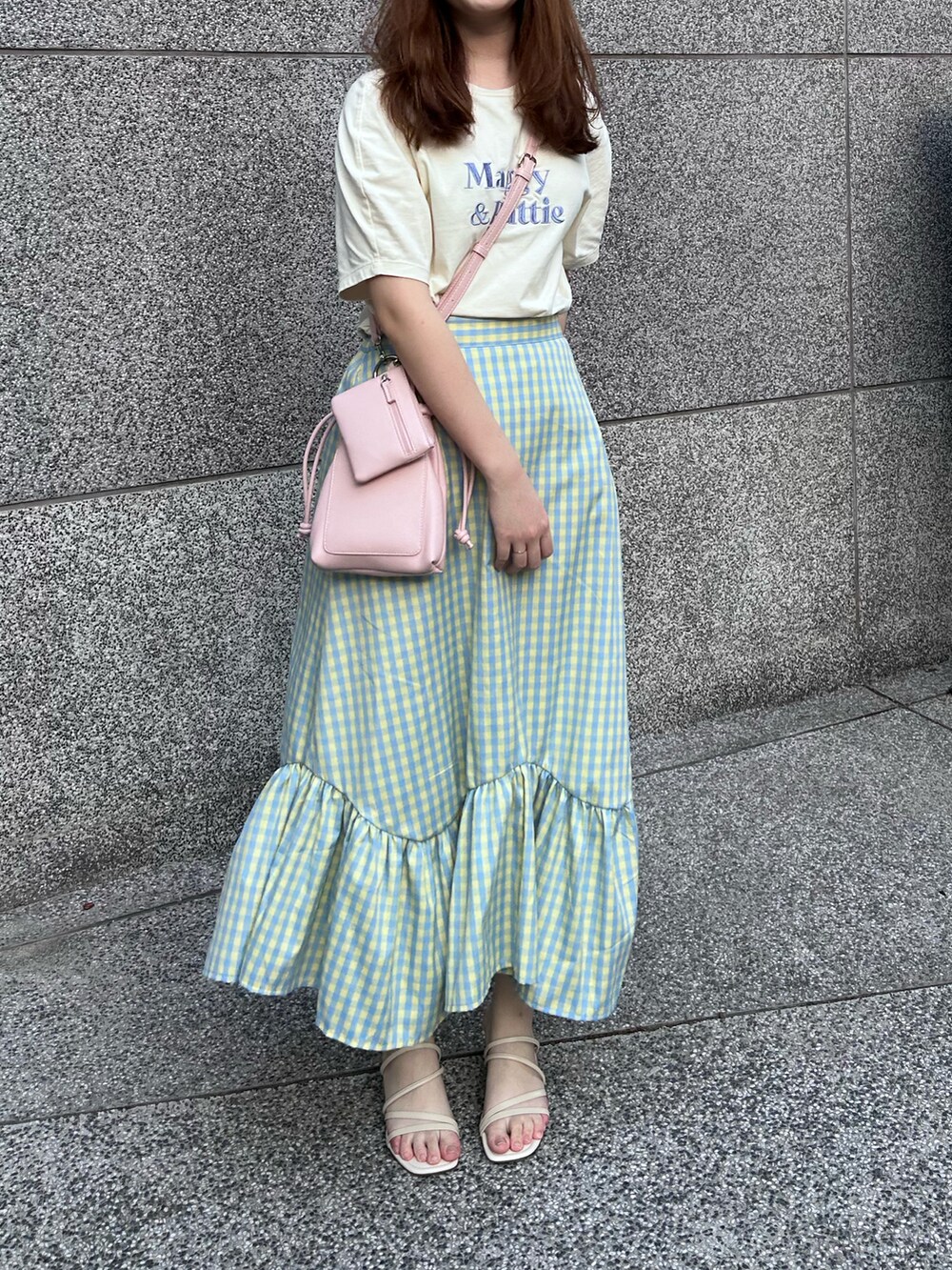 ブルー系のスカート、ピンク系のショルダーバッグ、ベージュ系のTシャツ/カットソーを着用したレディースの春コーディネートの3枚目の写真