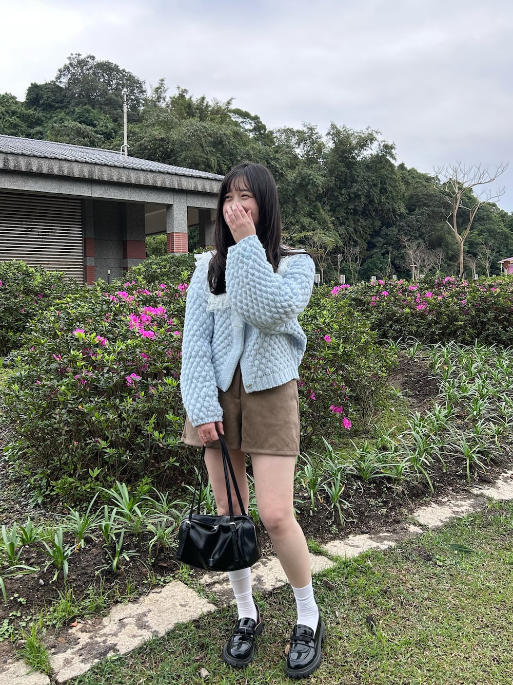 ブルー系のカーディガン/ボレロ、ブラウン系のその他パンツ、ブラック系のトートバッグを着用したレディースの冬コーディネートの2枚目の写真