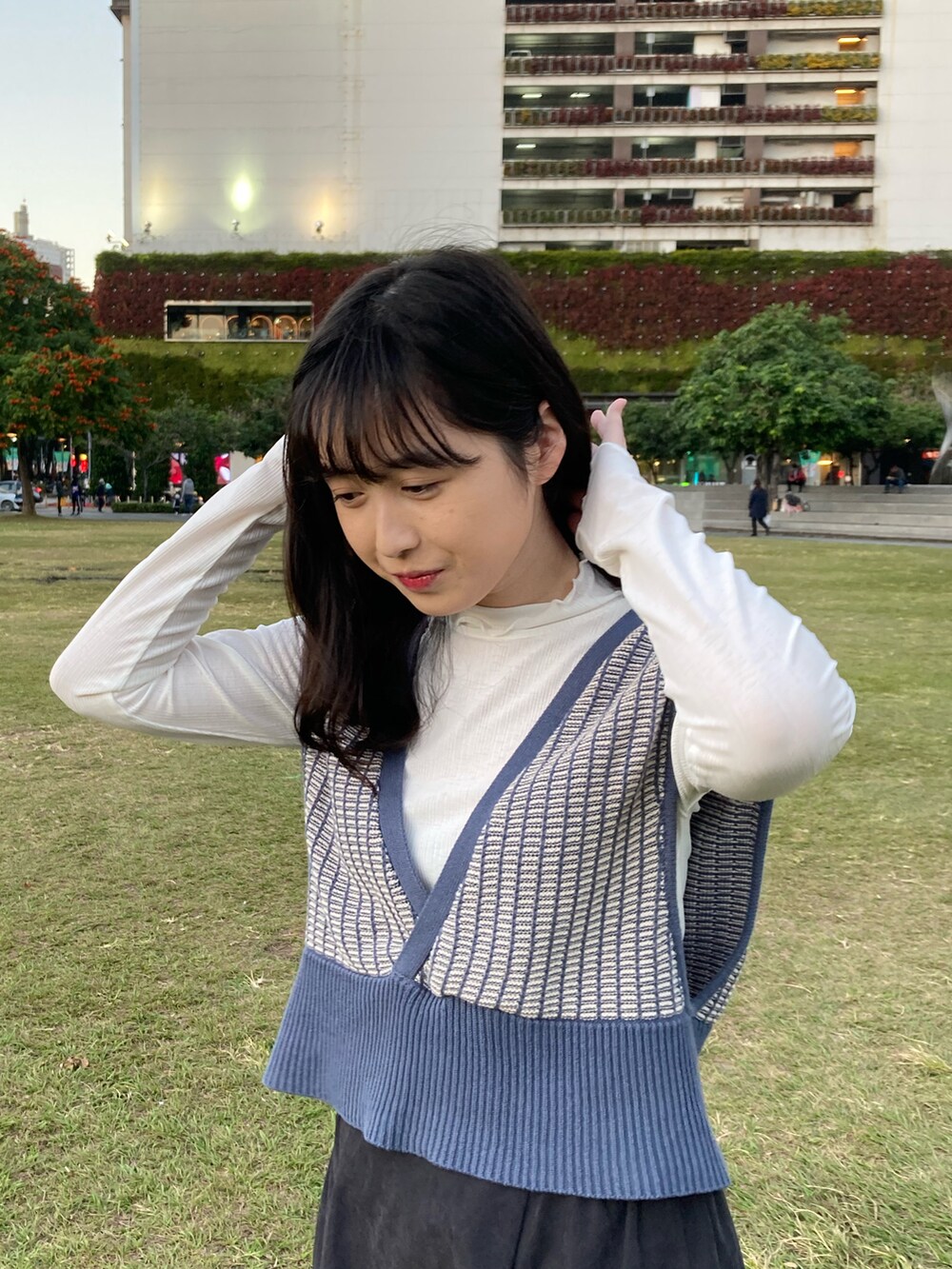 ブルー系のベスト、ブラック系のスカート、ブラック系のローファーを着用したレディースの冬コーディネートの2枚目の写真