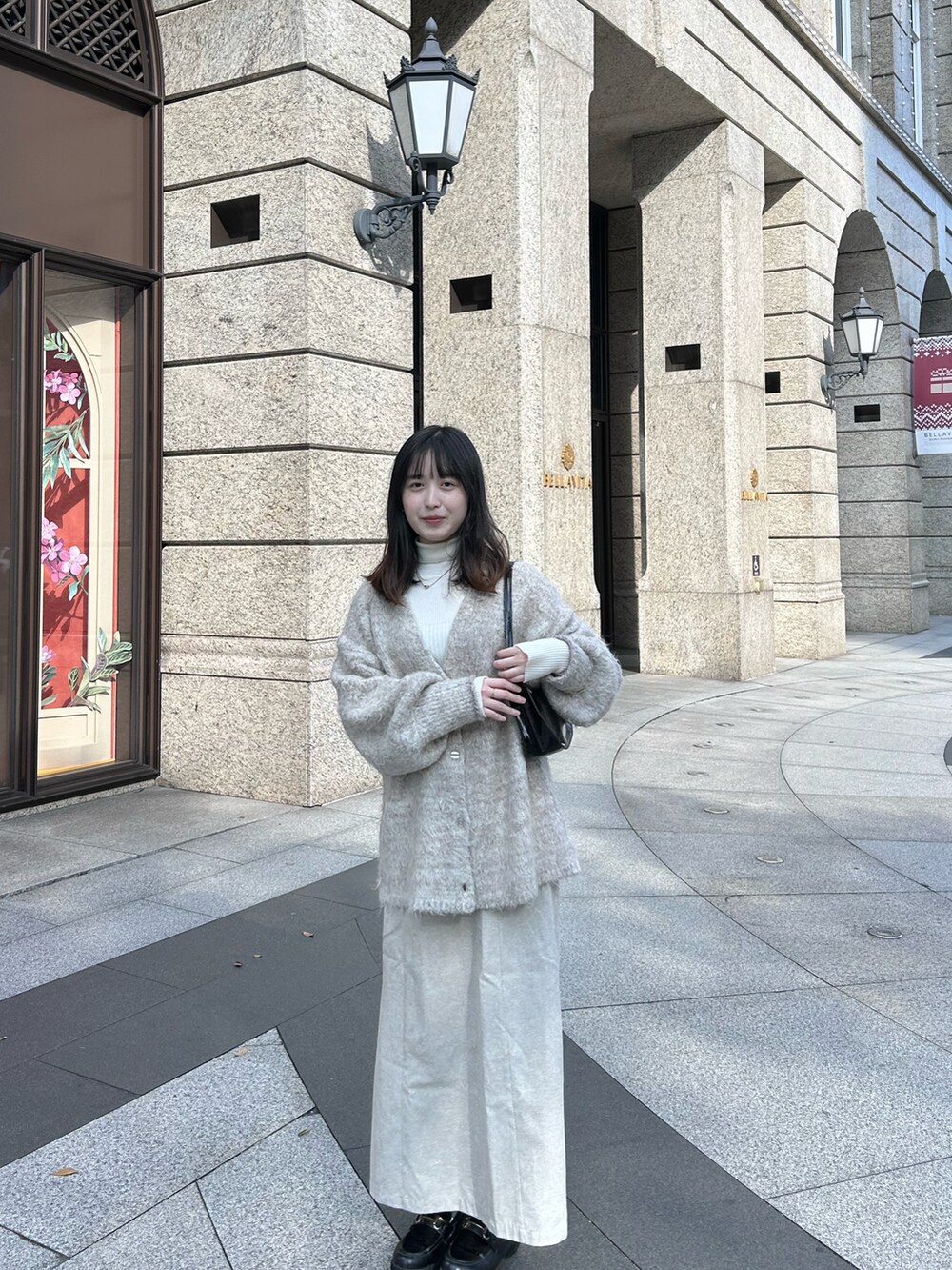 ホワイト系のカーディガン/ボレロ、ホワイト系のスカート、ホワイト系のニット/セーターを着用したレディースの冬コーディネートの2枚目の写真