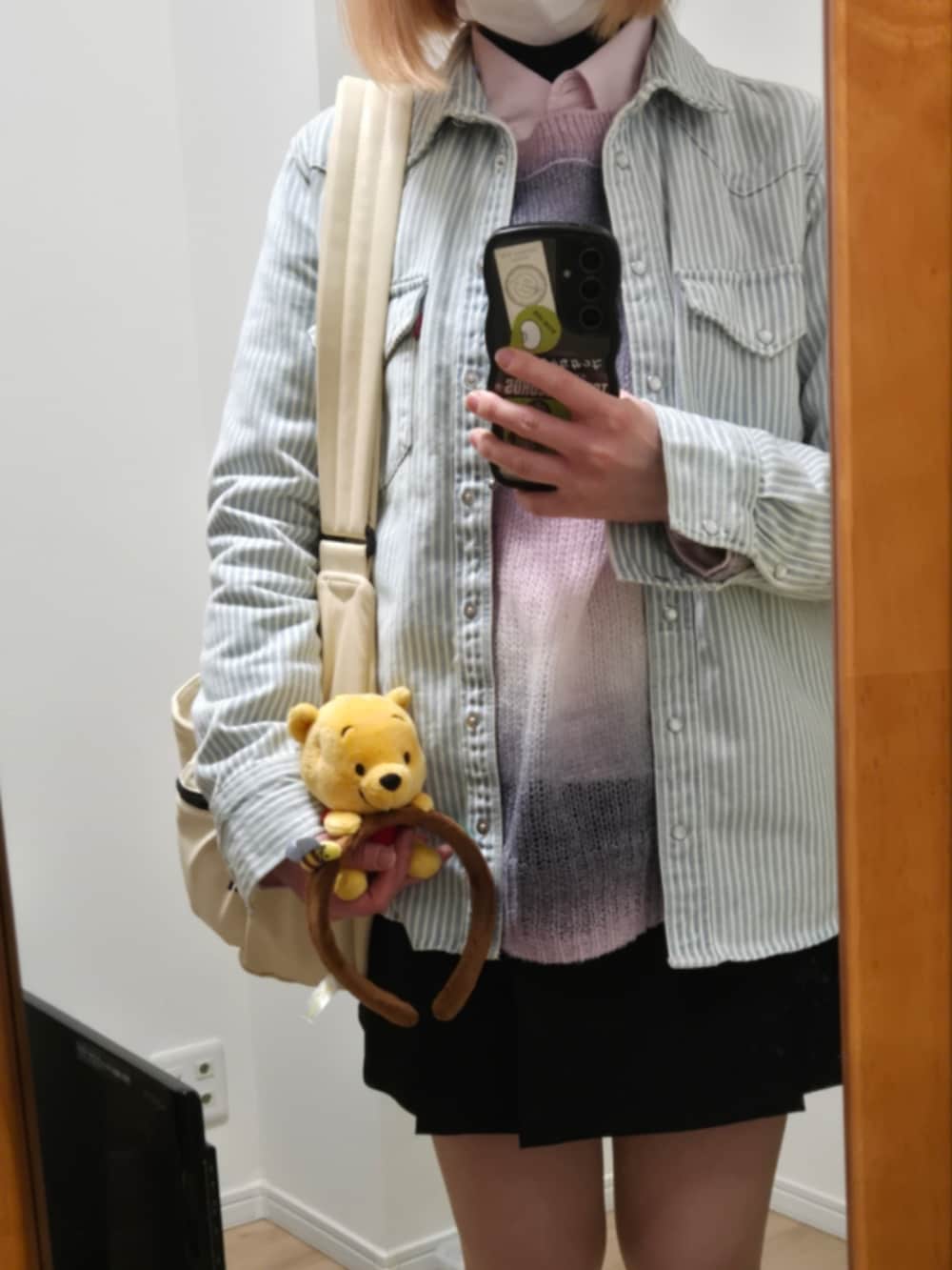 ブラック系のスカート、ベージュ系のブーツ、ホワイト系のシャツ/ブラウスを着用したレディースの春コーディネートの2枚目の写真