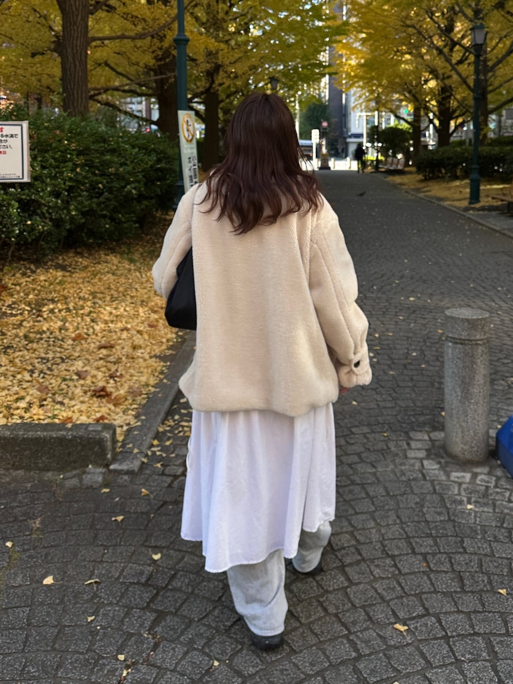 ベージュ系のステンカラーコート、グレー系のスウェットパンツを着用したレディースの冬コーディネートの4枚目の写真