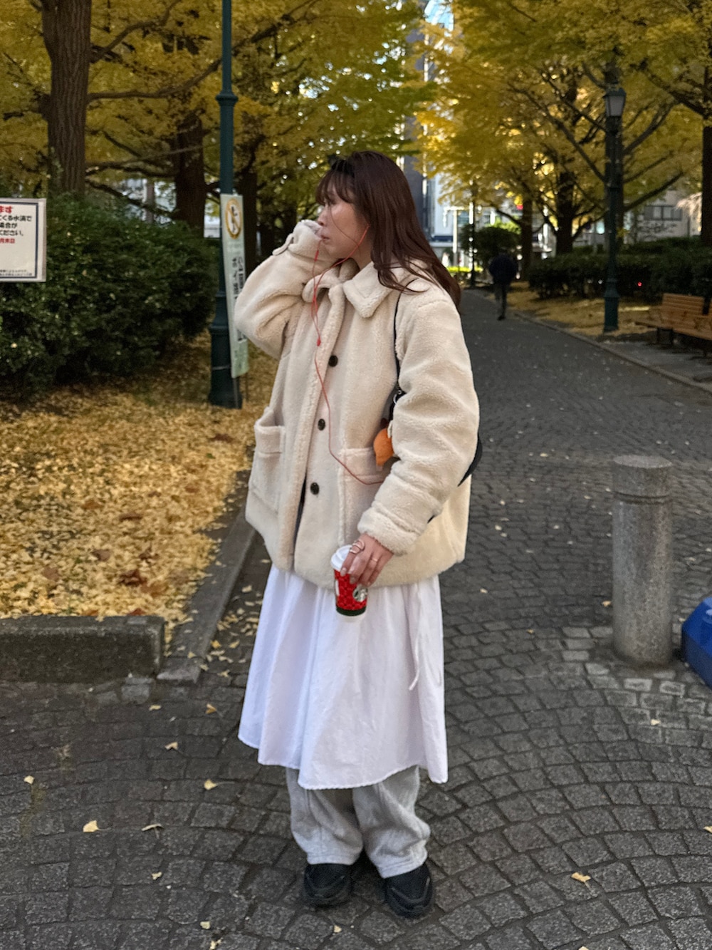 ベージュ系のステンカラーコート、グレー系のスウェットパンツを着用したレディースの冬コーディネートの5枚目の写真