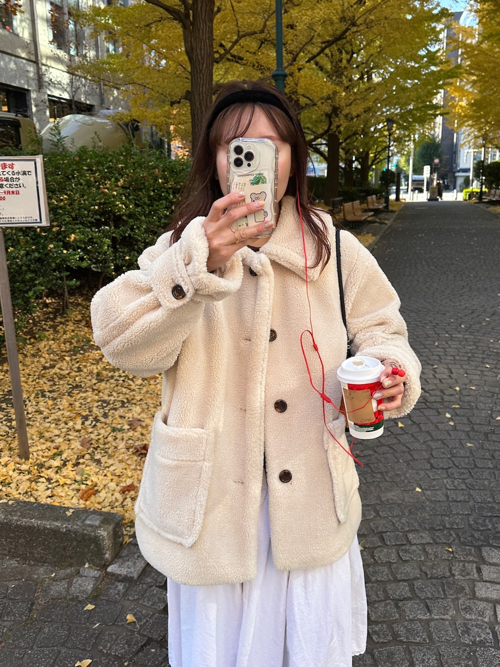 ベージュ系のステンカラーコート、グレー系のスウェットパンツを着用したレディースの冬コーディネートの2枚目の写真