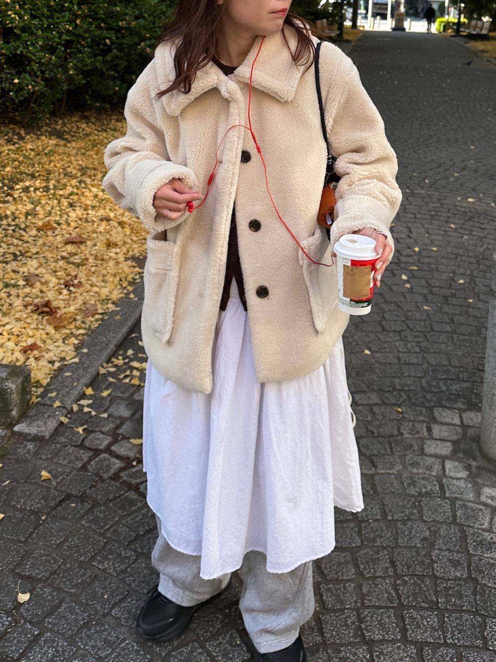 ベージュ系のステンカラーコート、グレー系のスウェットパンツを着用したレディースの冬コーディネートの3枚目の写真