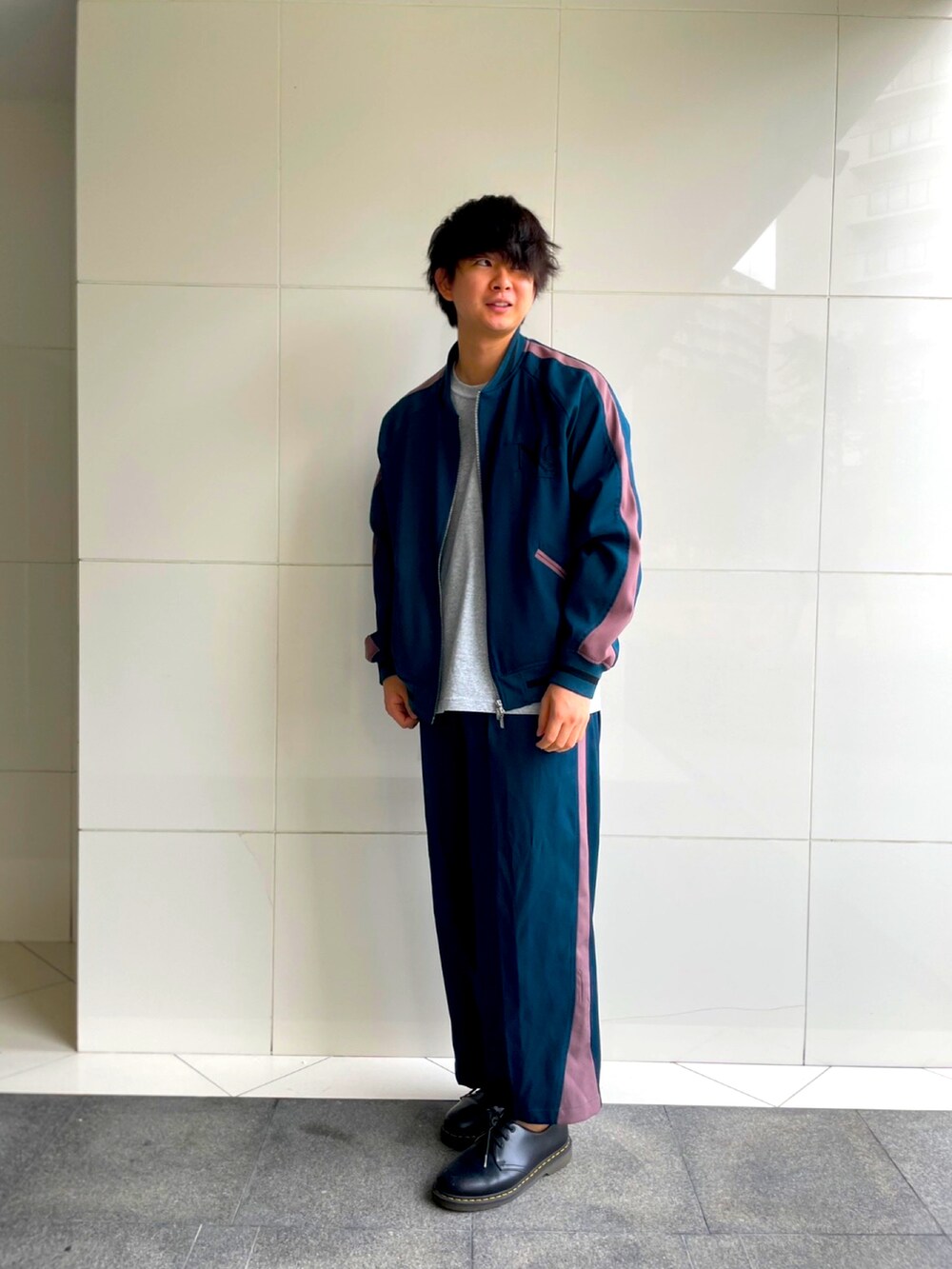 グリーン系のスラックス、グリーン系のスカジャン、グレー系のTシャツ/カットソーを着用したメンズの秋コーディネートの2枚目の写真