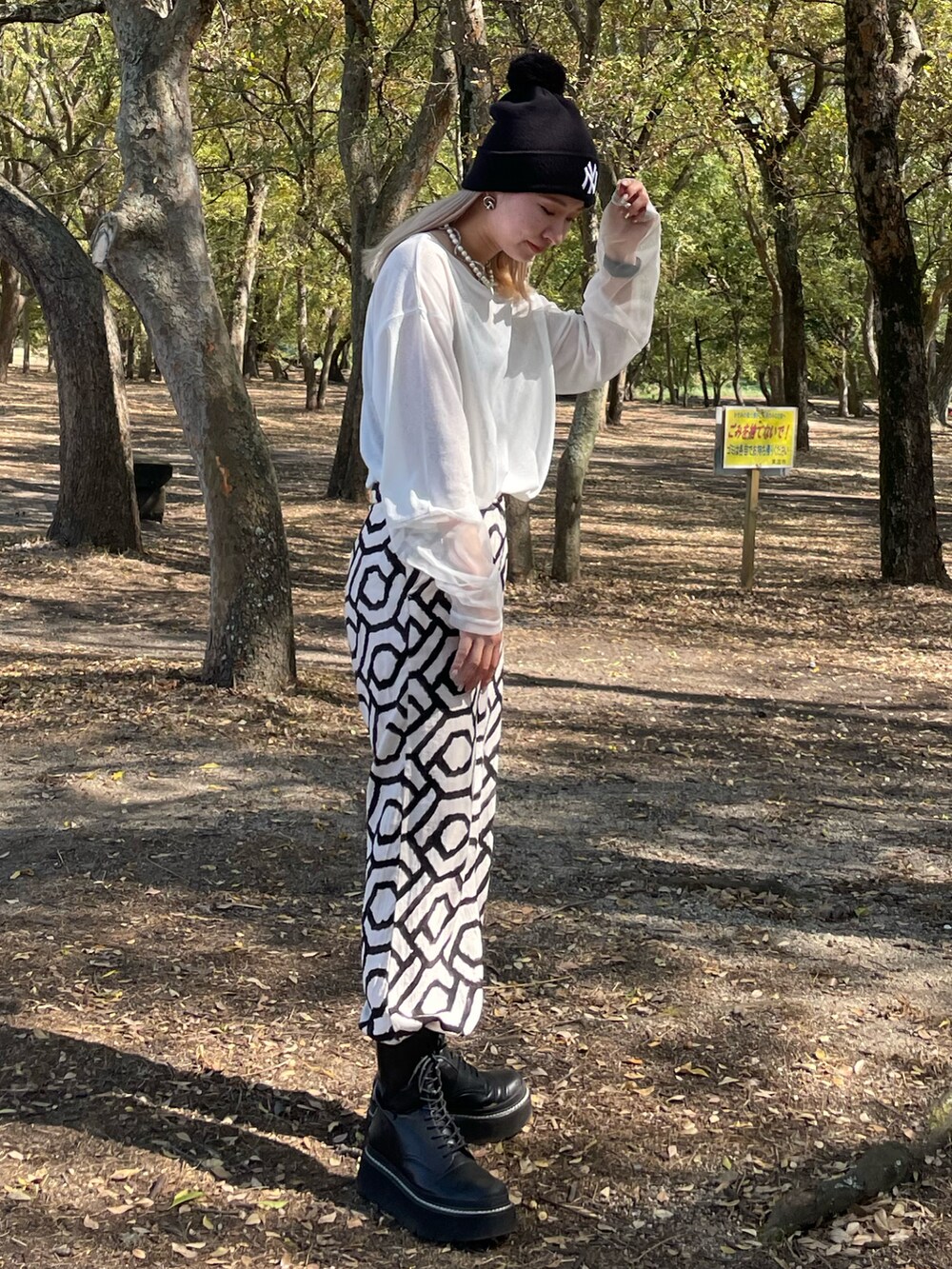 ホワイト系のTシャツ/カットソー、ブラック系のブーツを着用したレディースの秋コーディネートの2枚目の写真