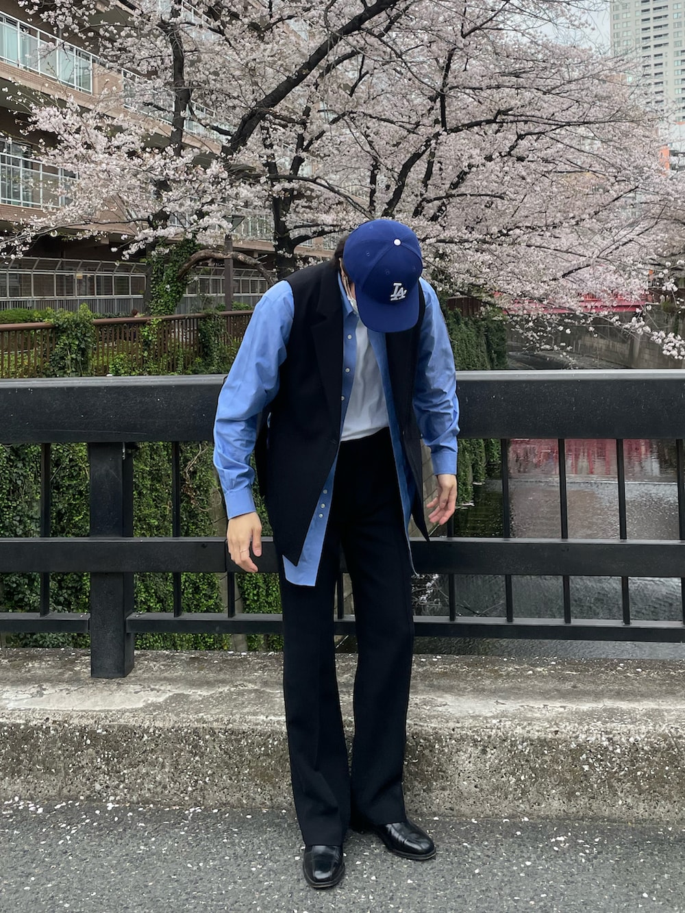 ブラック系のスラックス、ブラック系のベスト、ホワイト系のTシャツ/カットソーを着用したメンズの夏コーディネートの2枚目の写真