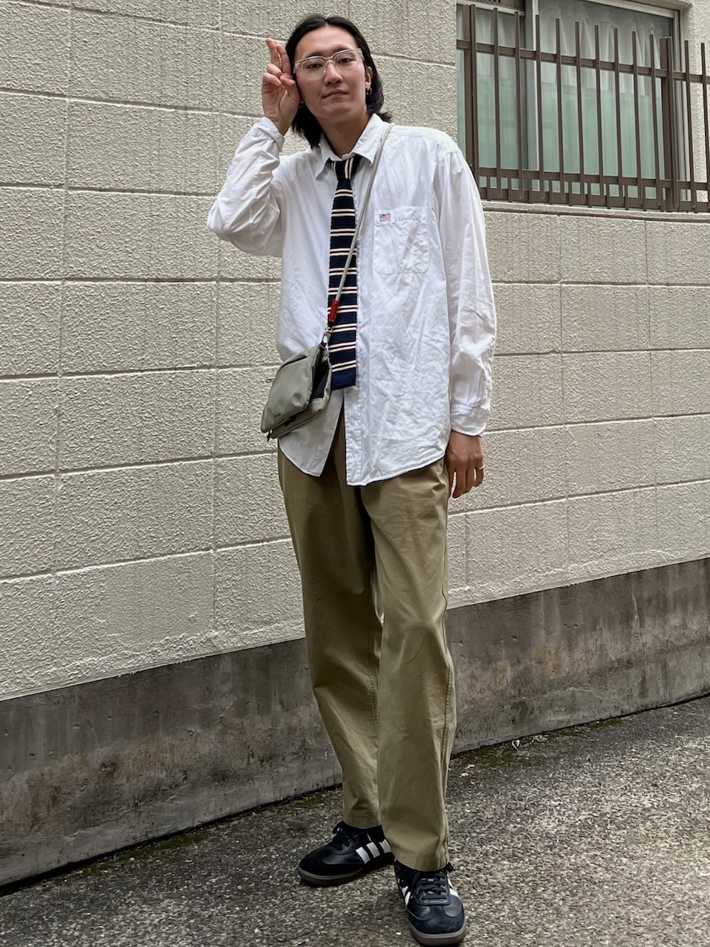 グレー系のショルダーバッグ、ホワイト系のシャツ/ブラウス、ブラック系のスニーカーを着用したメンズの夏コーディネートの2枚目の写真