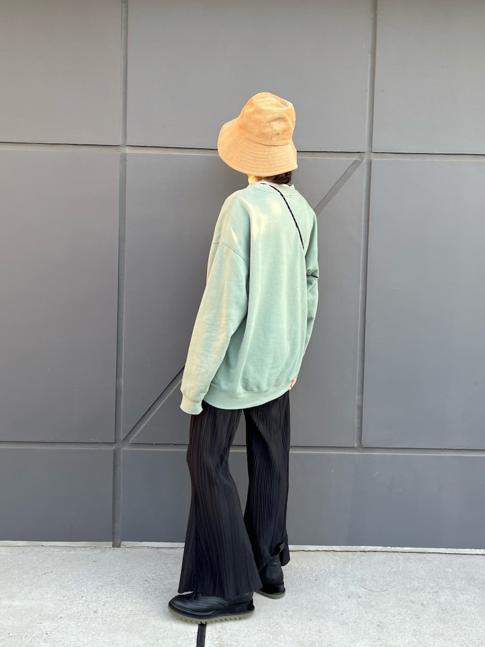 グリーン系のスウェット、ブラック系のパンツ、グリーン系のブーツを着用したレディースの春コーディネートの3枚目の写真