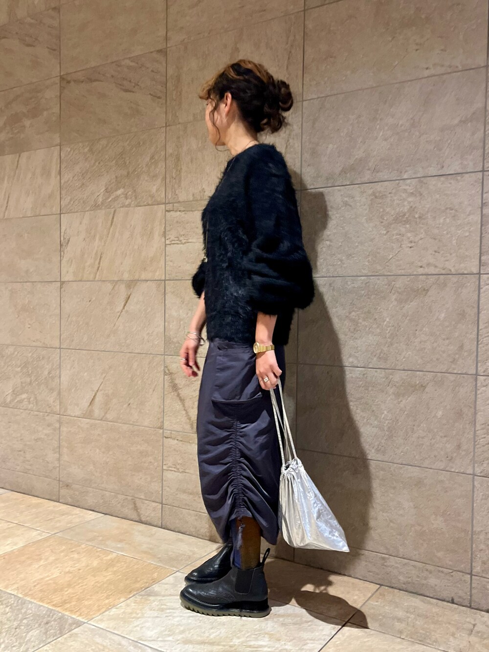 ブラック系のニット/セーター、ブルー系のスカート、グリーン系のブーツを着用したレディースの冬コーディネートの2枚目の写真