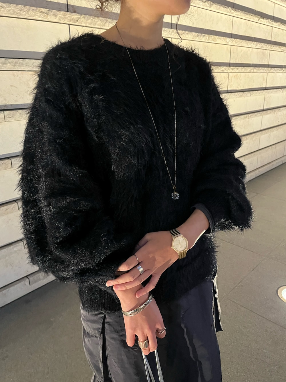 ブラック系のニット/セーター、ブルー系のスカート、グリーン系のブーツを着用したレディースの冬コーディネートの5枚目の写真