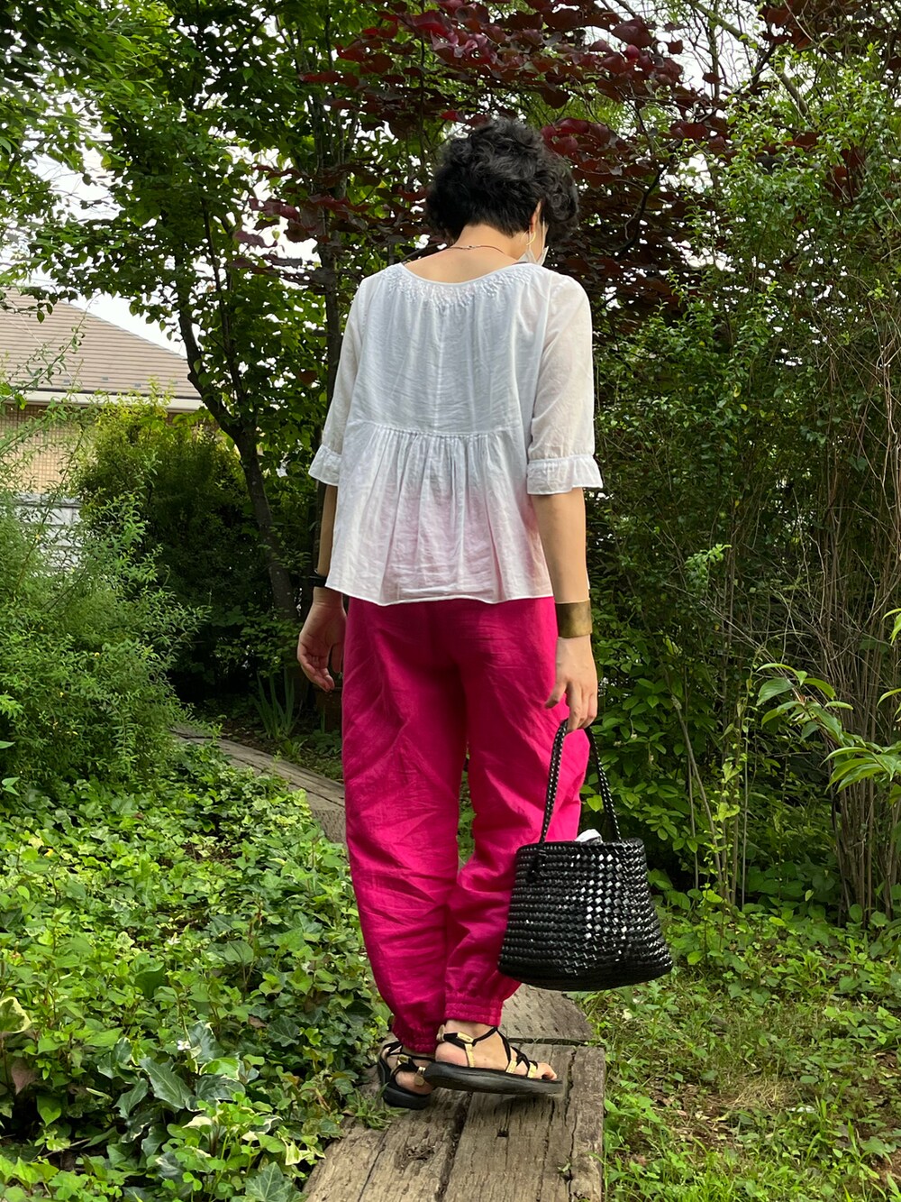 ホワイト系のシャツ/ブラウス、ピンク系のパンツ、ブラック系のバッグを着用したレディースの夏コーディネートの2枚目の写真