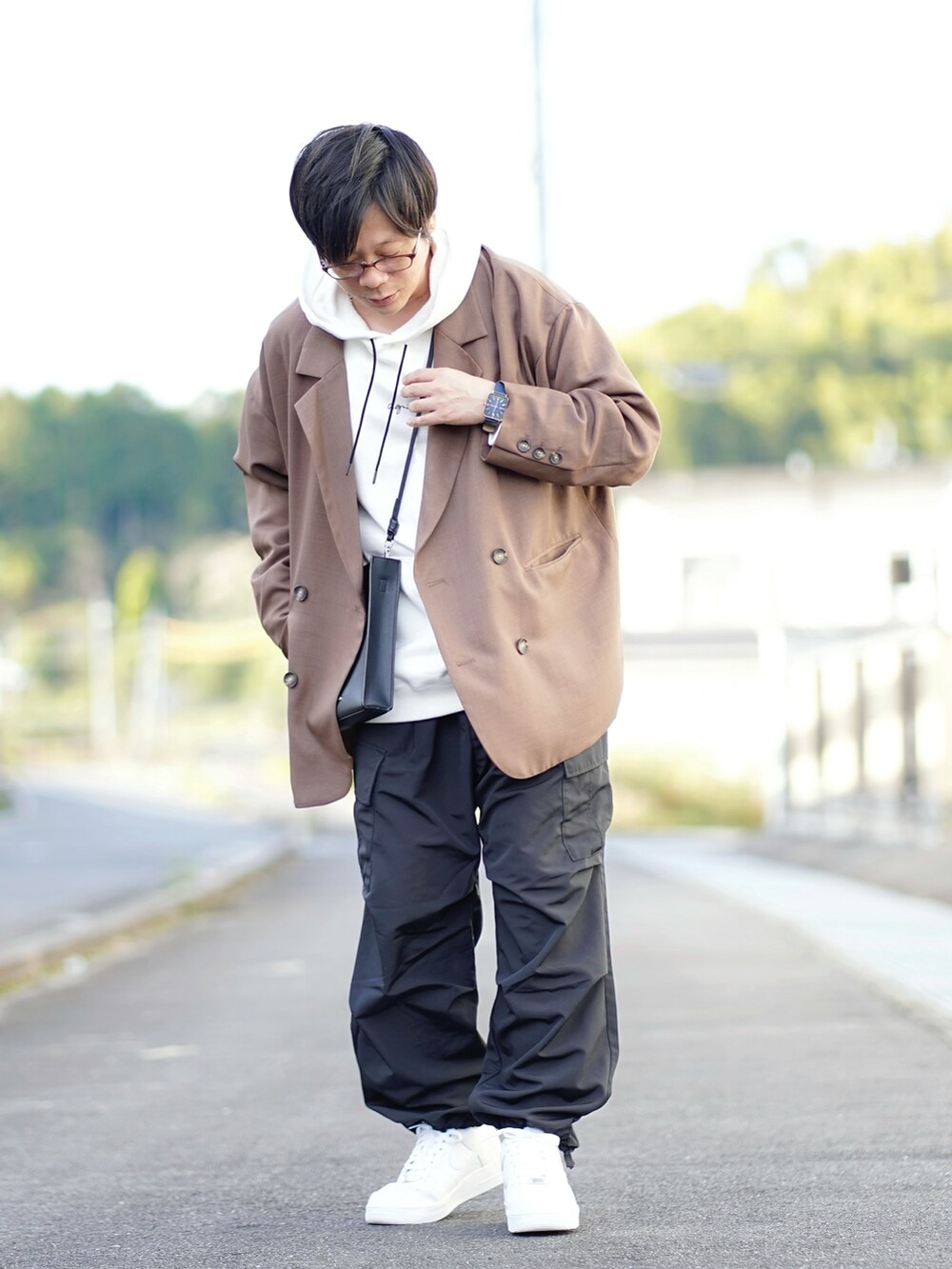 ホワイト系のパーカー、ブラウン系のテーラードジャケット、ブラック系のカーゴパンツを着用したメンズの秋コーディネートの2枚目の写真