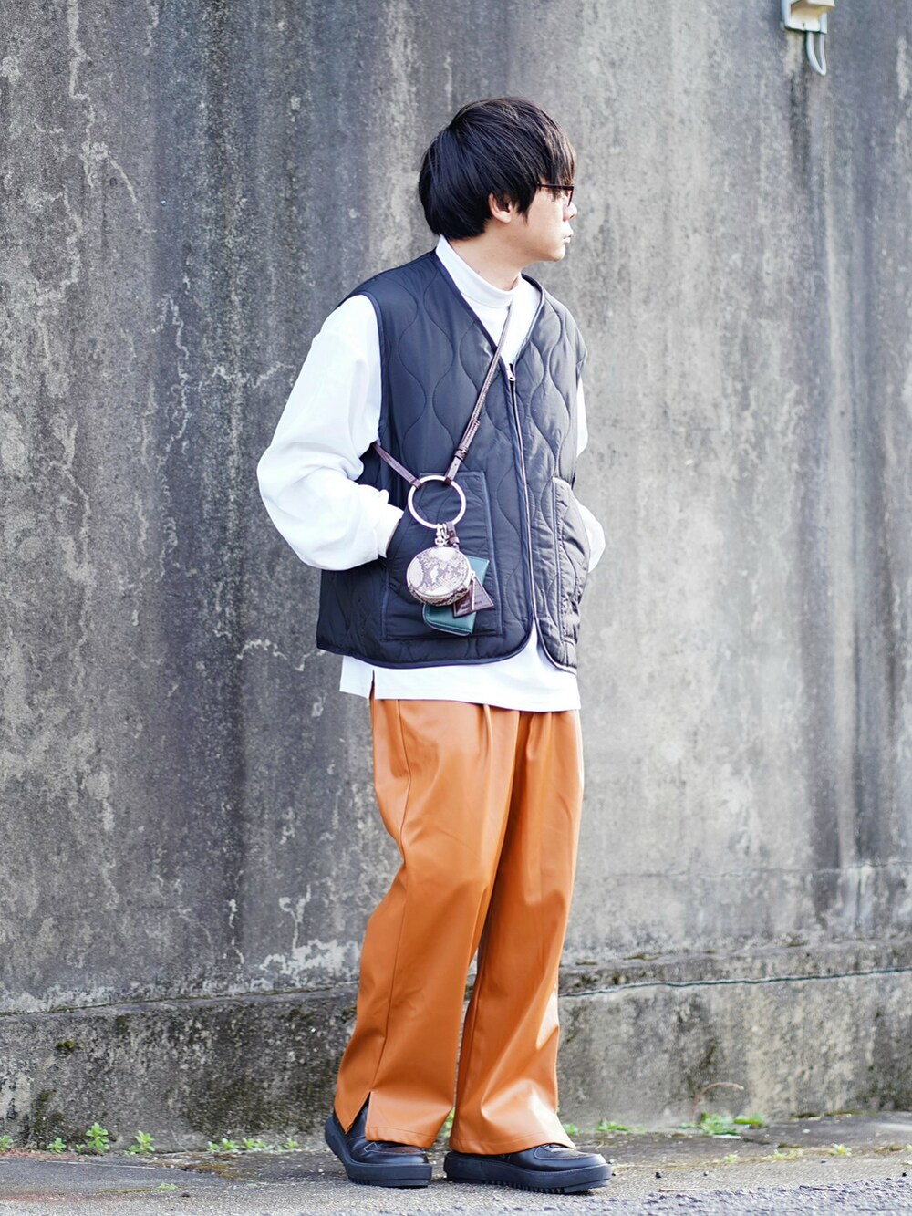 ホワイト系のブルゾン、ホワイト系のTシャツ/カットソー、ブラック系のベストを着用したメンズの秋コーディネートの2枚目の写真