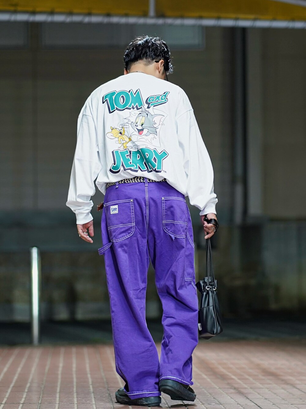 ホワイト系のTシャツ/カットソー、パープル系のデニムパンツ、ブラック系のスニーカーを着用したメンズの秋コーディネートの2枚目の写真