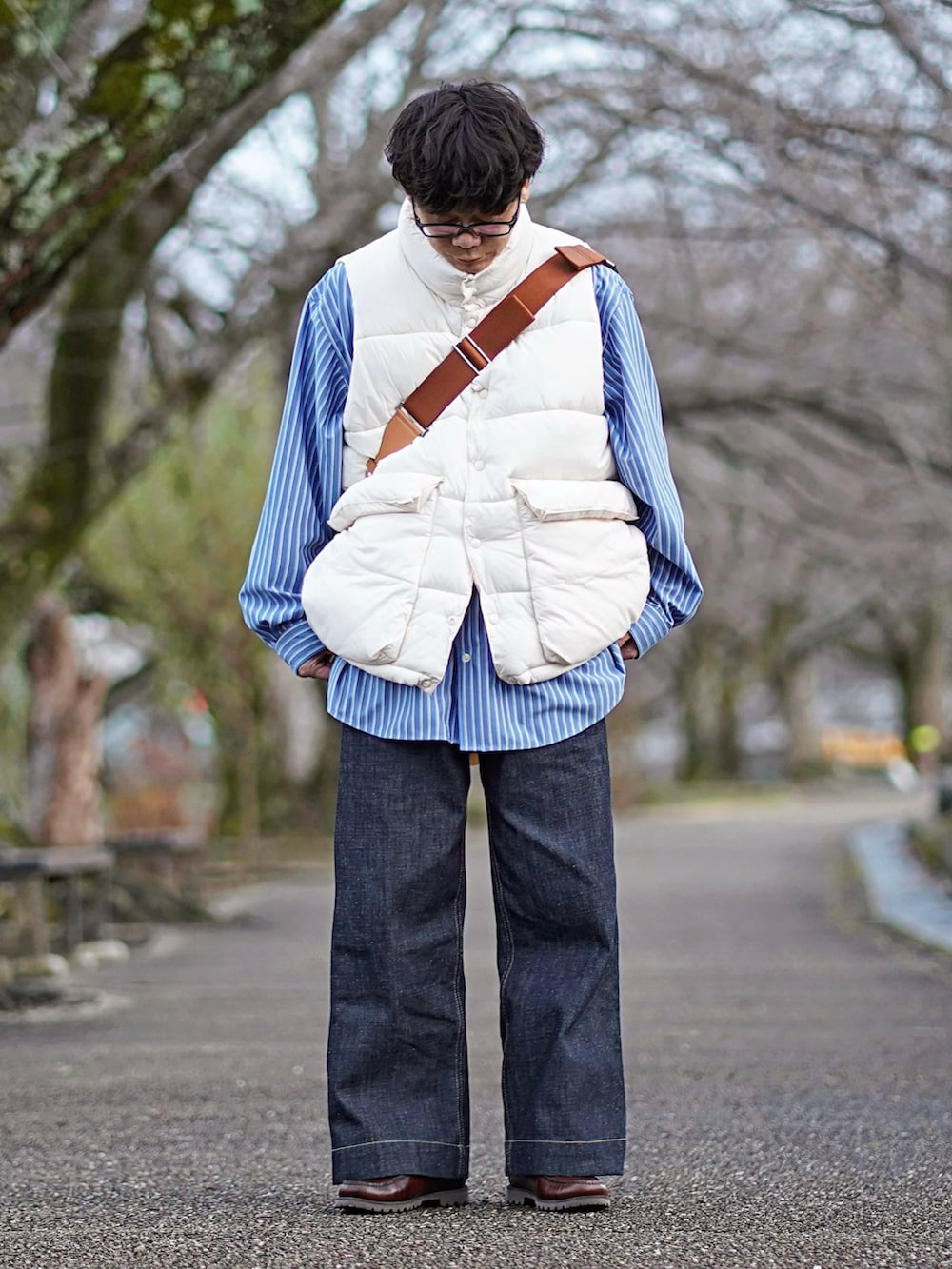 ブルー系のシャツ/ブラウス、ホワイト系のダウンベスト、ブルー系のデニムパンツを着用したメンズの冬コーディネートの2枚目の写真