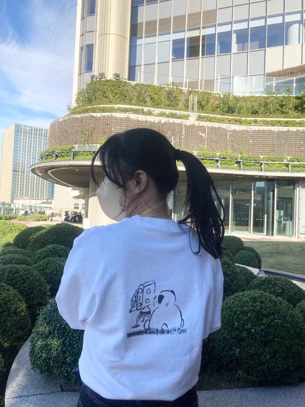 ホワイト系のスウェット、ブルー系のデニムパンツ、ブラック系のトートバッグを着用したレディースの秋コーディネートの3枚目の写真