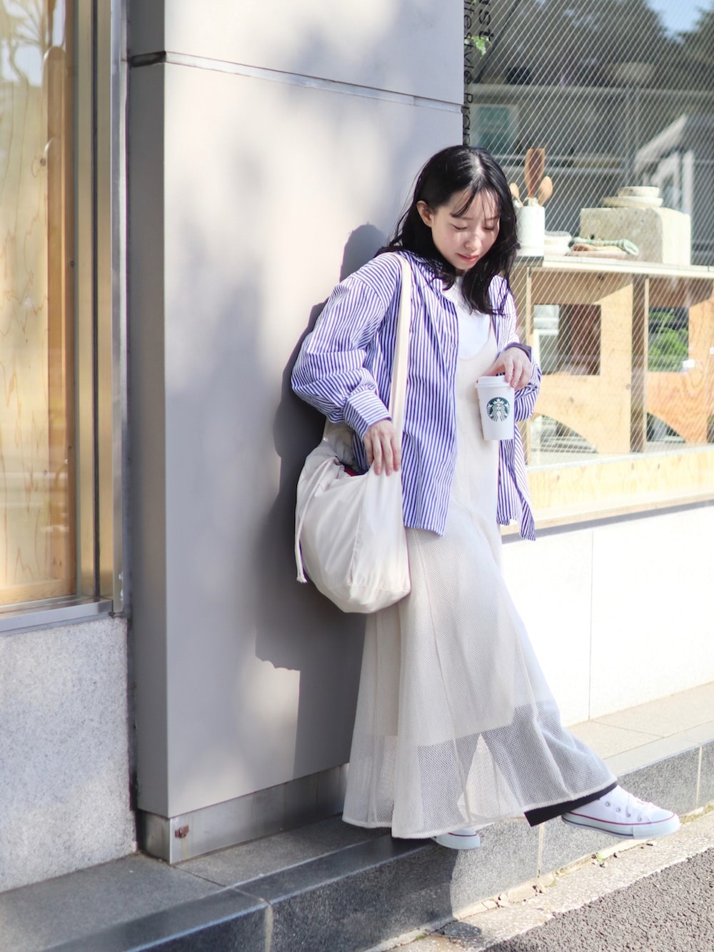 ホワイト系のショルダーバッグ、ホワイト系のワンピース、ホワイト系のTシャツ/カットソーを着用したレディースの春コーディネートの3枚目の写真