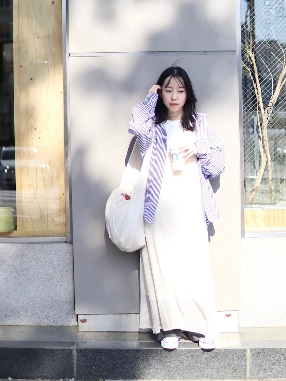 ホワイト系のショルダーバッグ、ホワイト系のワンピース、ホワイト系のTシャツ/カットソーを着用したレディースの春コーディネートの2枚目の写真