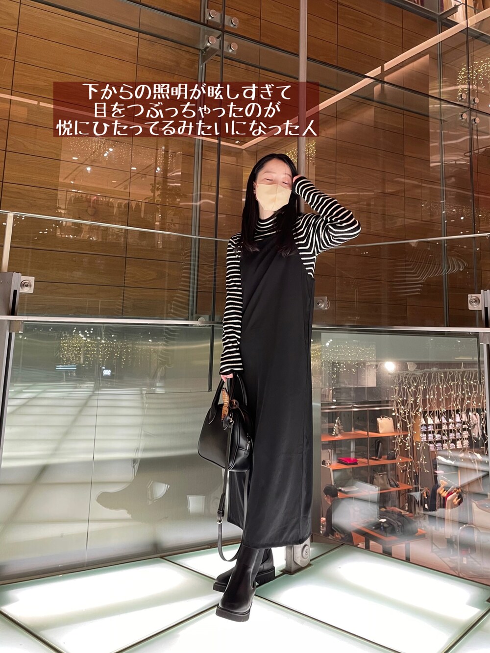 ブラック系のワンピース、ブラック系のブーツ、ブラック系のショルダーバッグを着用したレディースの冬コーディネートの3枚目の写真